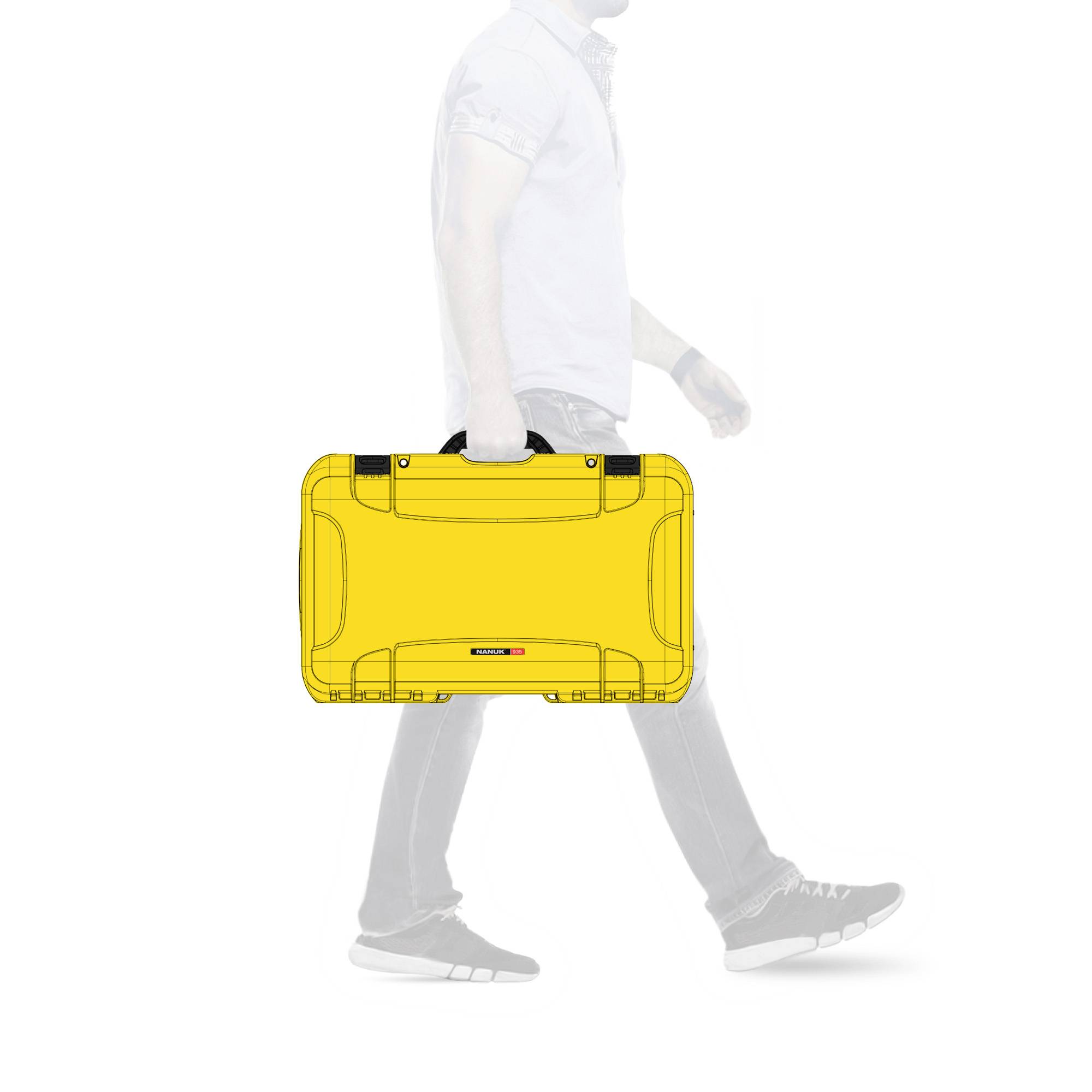 Eine Person in Businesskleidung geht nach rechts und trägt einen gelben Koffer.