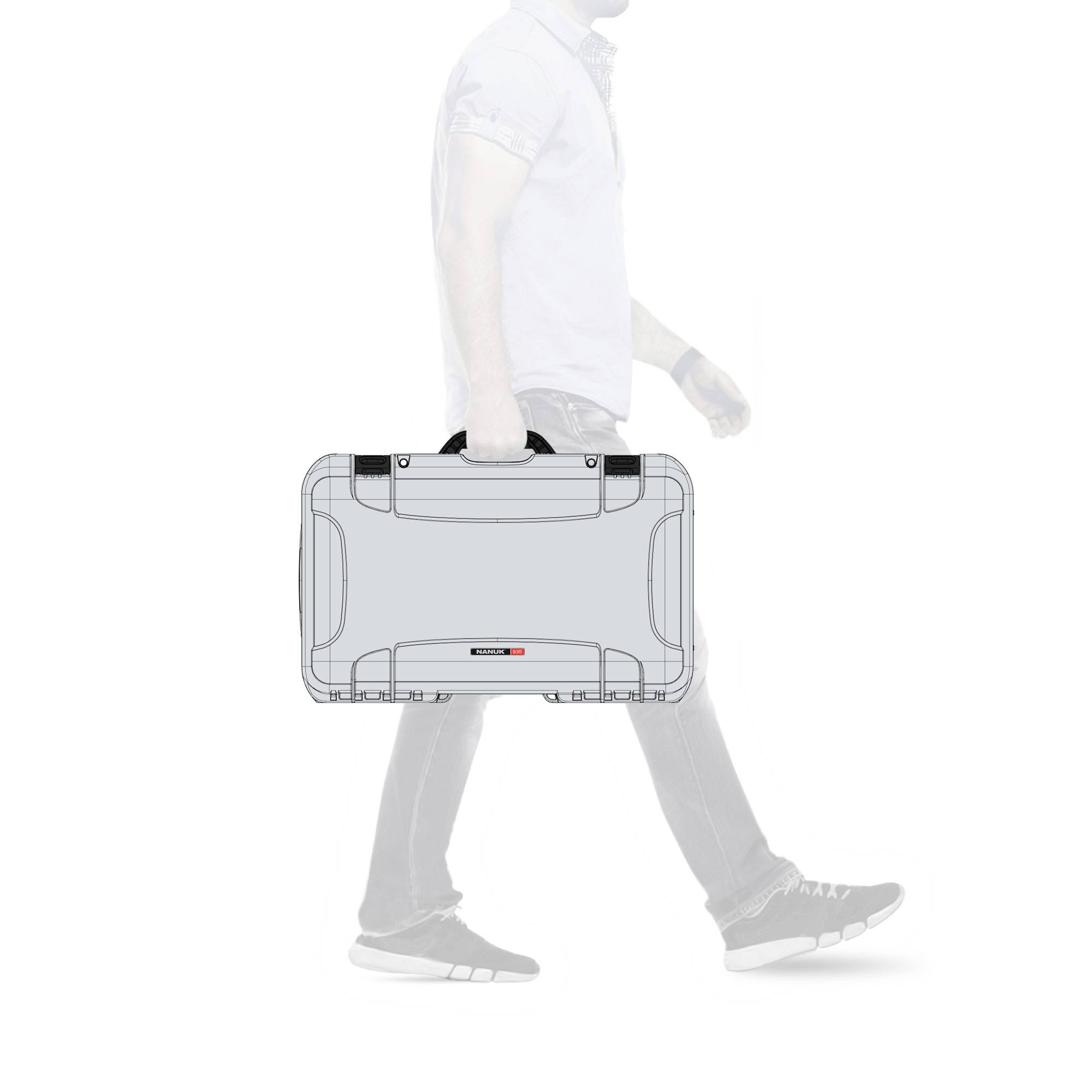 Eine Person hält einen grauen Hartschalenkoffer mit schwarzem Griff. Der Fokus liegt auf dem Koffer. Die Person ist teilweise sichtbar.