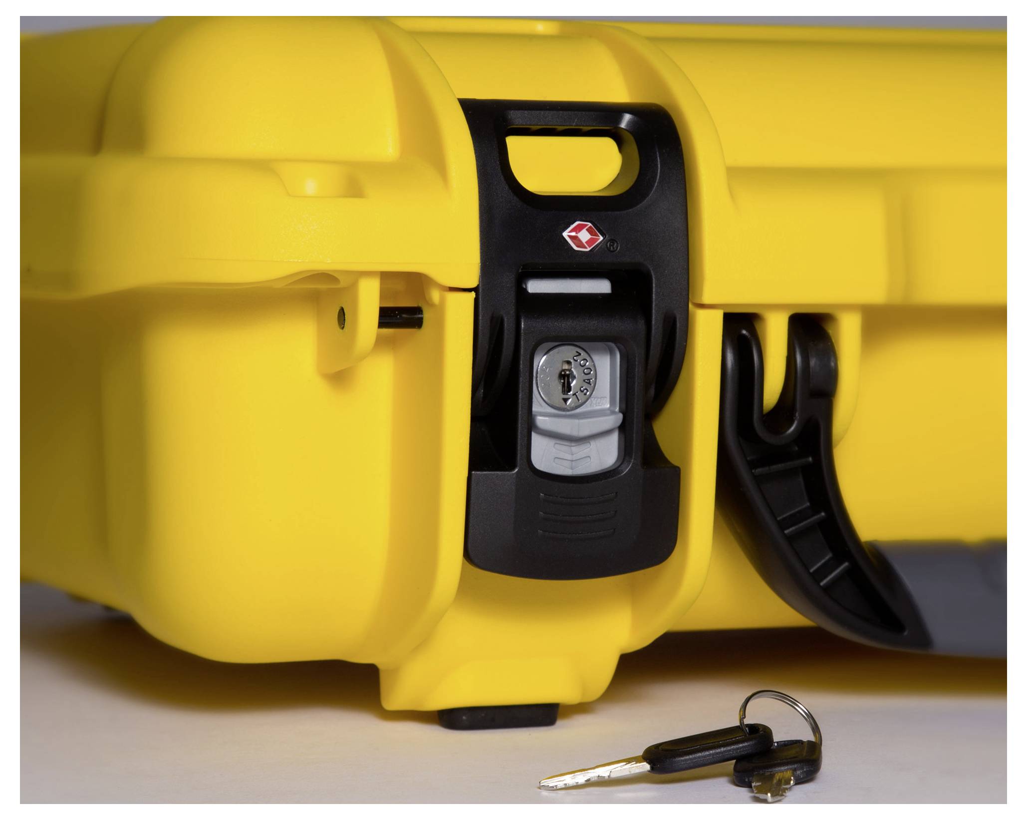 Gelber Hartschalenkoffer mit einem schwarzen Schloss, daneben liegt ein Schlüssel. Der Koffer scheint sicher verschlossen zu sein.