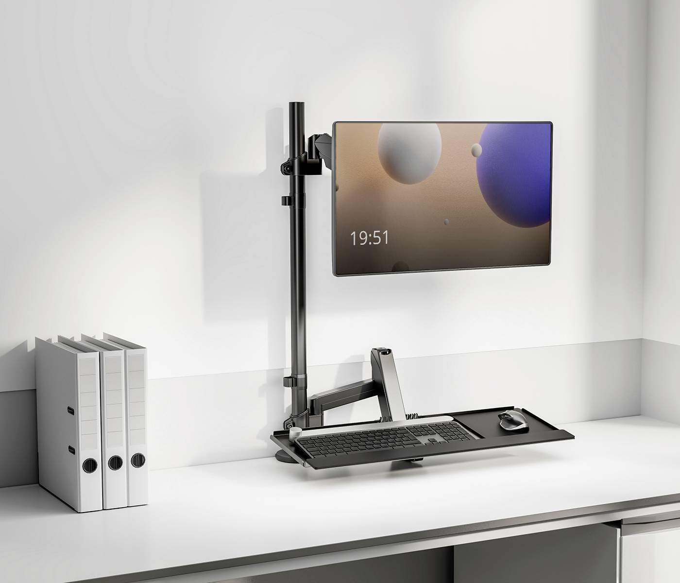 Ein moderner Arbeitsplatz mit einem an der Wand montierten Monitor, Tastatur und Maus auf einem höhenverstellbaren Schreibtischarm.