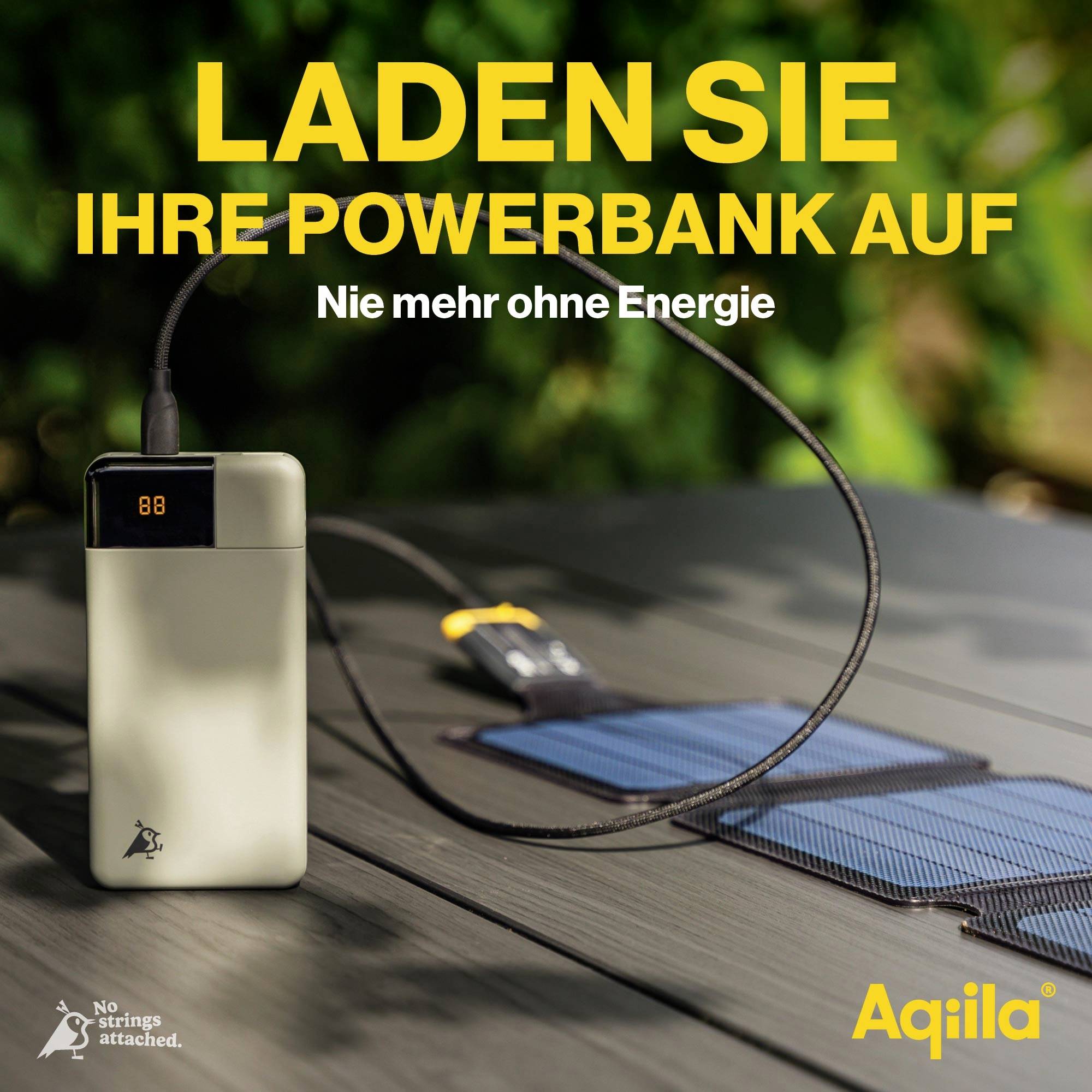 Eine Powerbank wird mit einem Solarpanel aufgeladen. Text: 'LADEN SIE IHRE POWERBANK AUF. Nie mehr ohne Energie.' Marke: Aqiila.