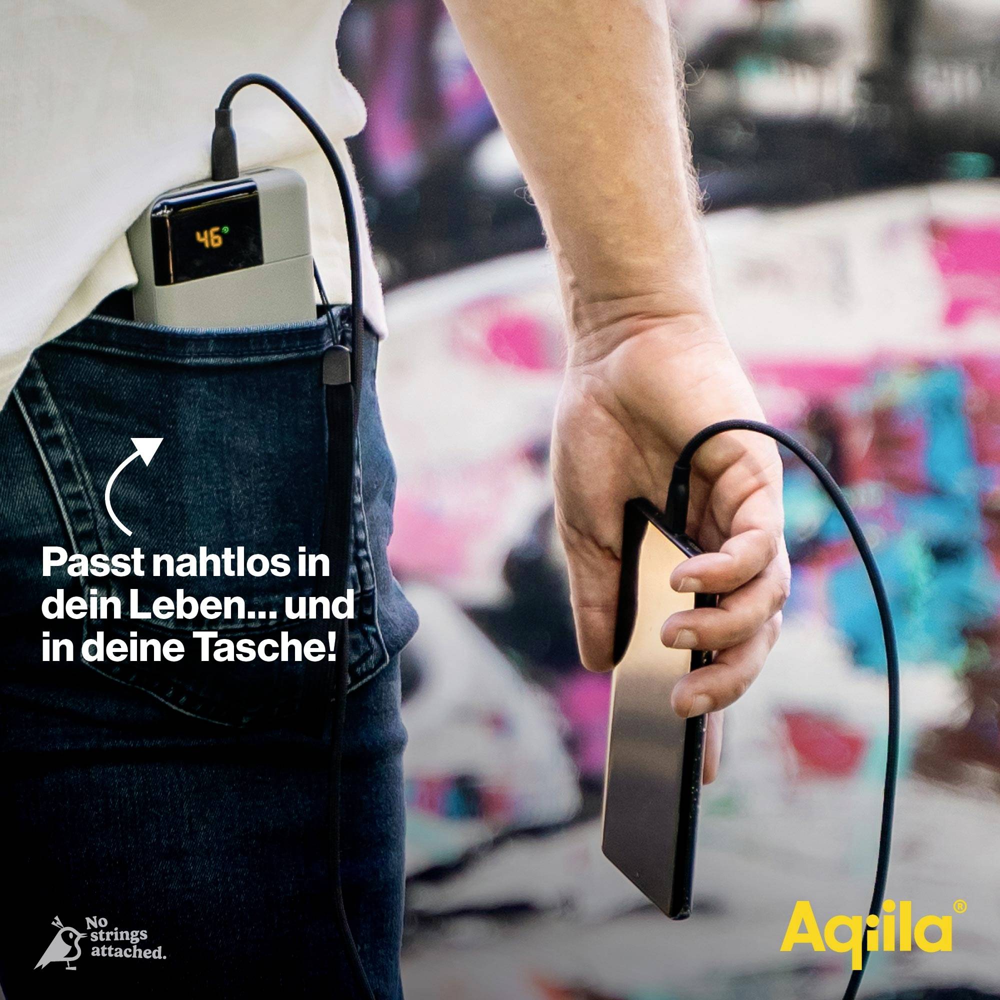 Person hält ein Smartphone, das mit einer Powerbank in der Hosentasche verbunden ist. Text auf dem Bild: 'Passt nahtlos in dein Leben... und in deine Tasche!'