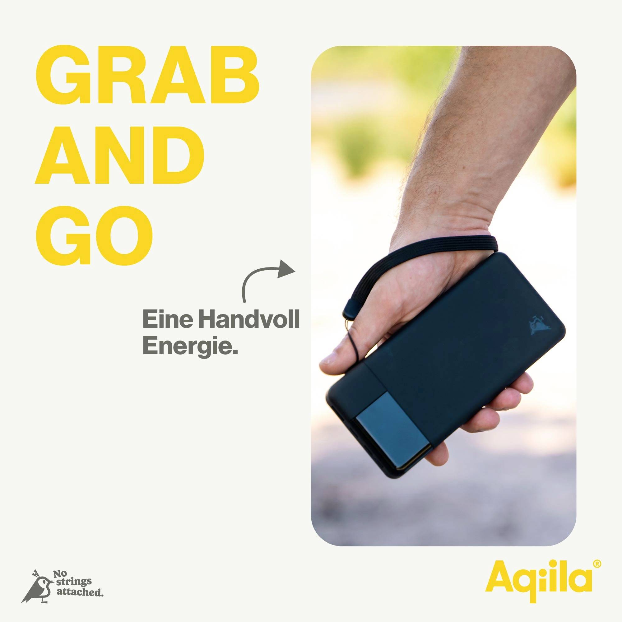 Eine Person hält eine tragbare Powerbank mit einer Handschlaufe. Text: 'Grab and Go - Eine Handvoll Energie'. Marke: Aqila.