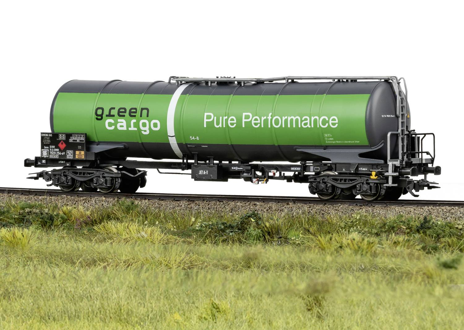 Grüner Kesselwagen mit der Aufschrift 'green cargo' und 'Pure Performance' auf Bahngleisen; Seitenansicht auf Graslandschaft.