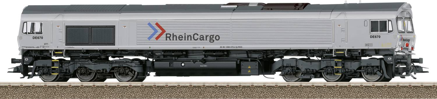 Eine silberne Lokomotive mit 'RheinCargo' Logo steht auf einem Gleis, seitliche Ansicht.