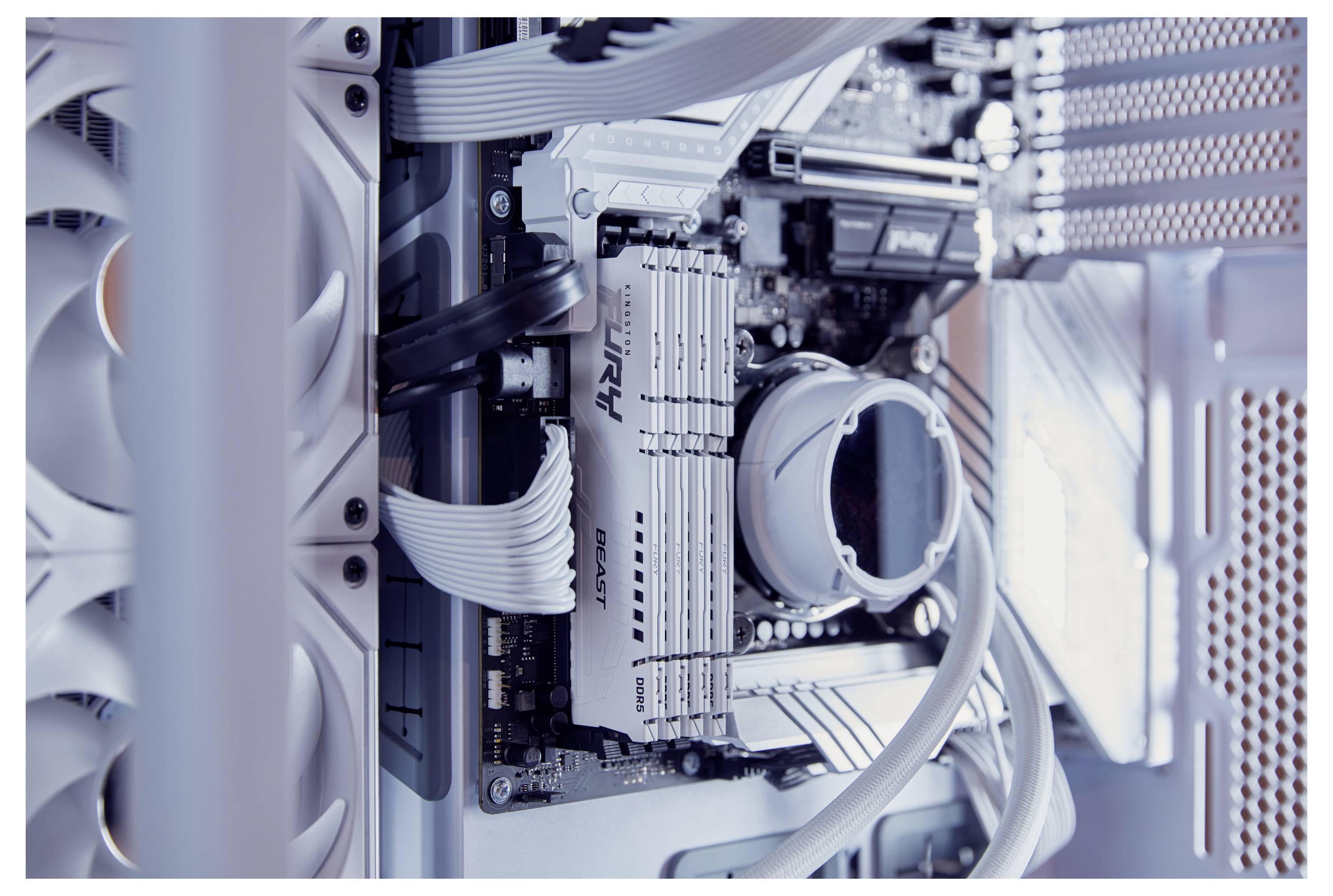 Innenansicht eines Computers mit sichtbarer Hauptplatine, RAM-Speichermodulen, CPU-Kühler und Kabeln in einem Gehäuse.