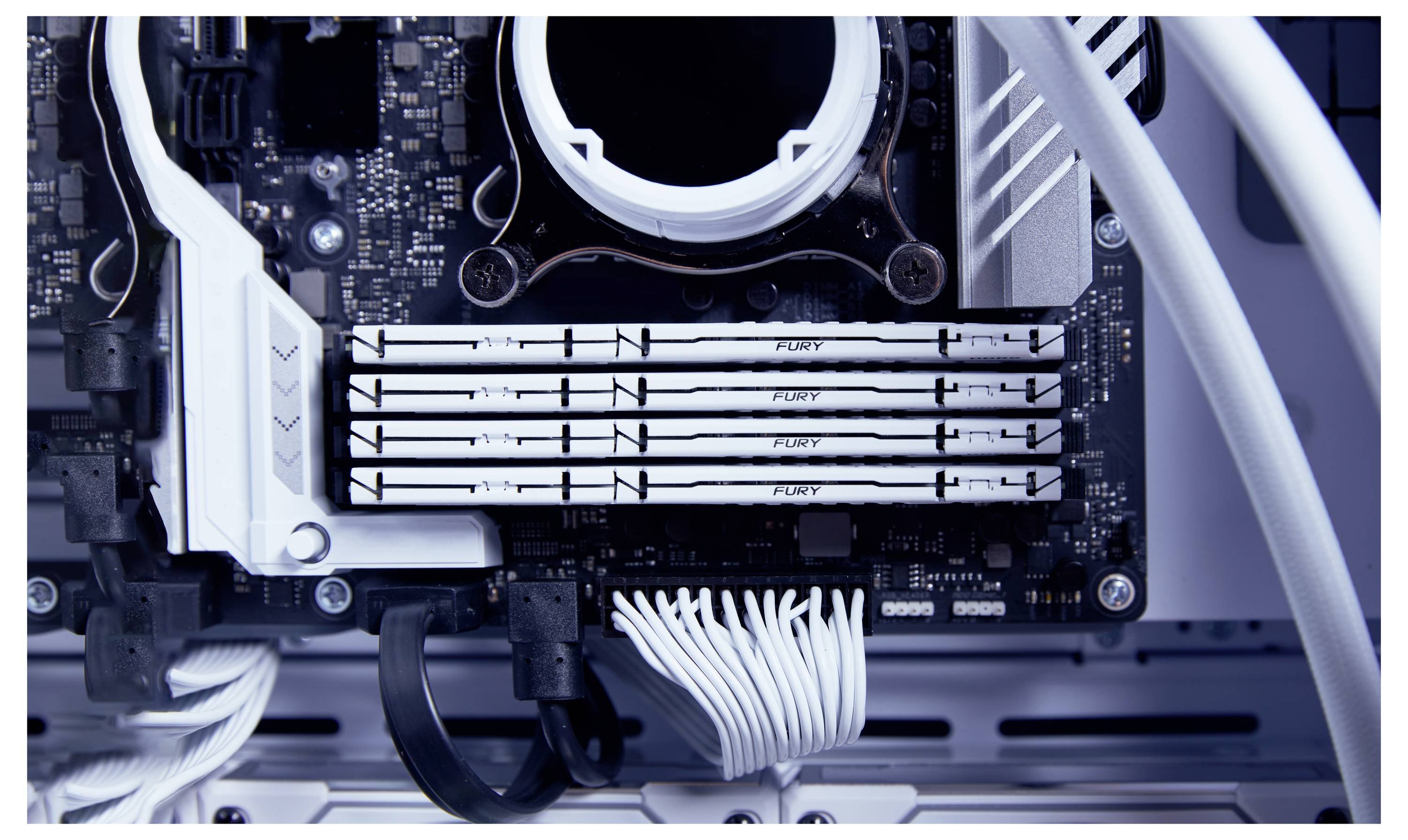 Nahaufnahme eines Computer-Motherboards mit vier RAM-Riegeln in einem gut organisierten PC-Gehäuse.