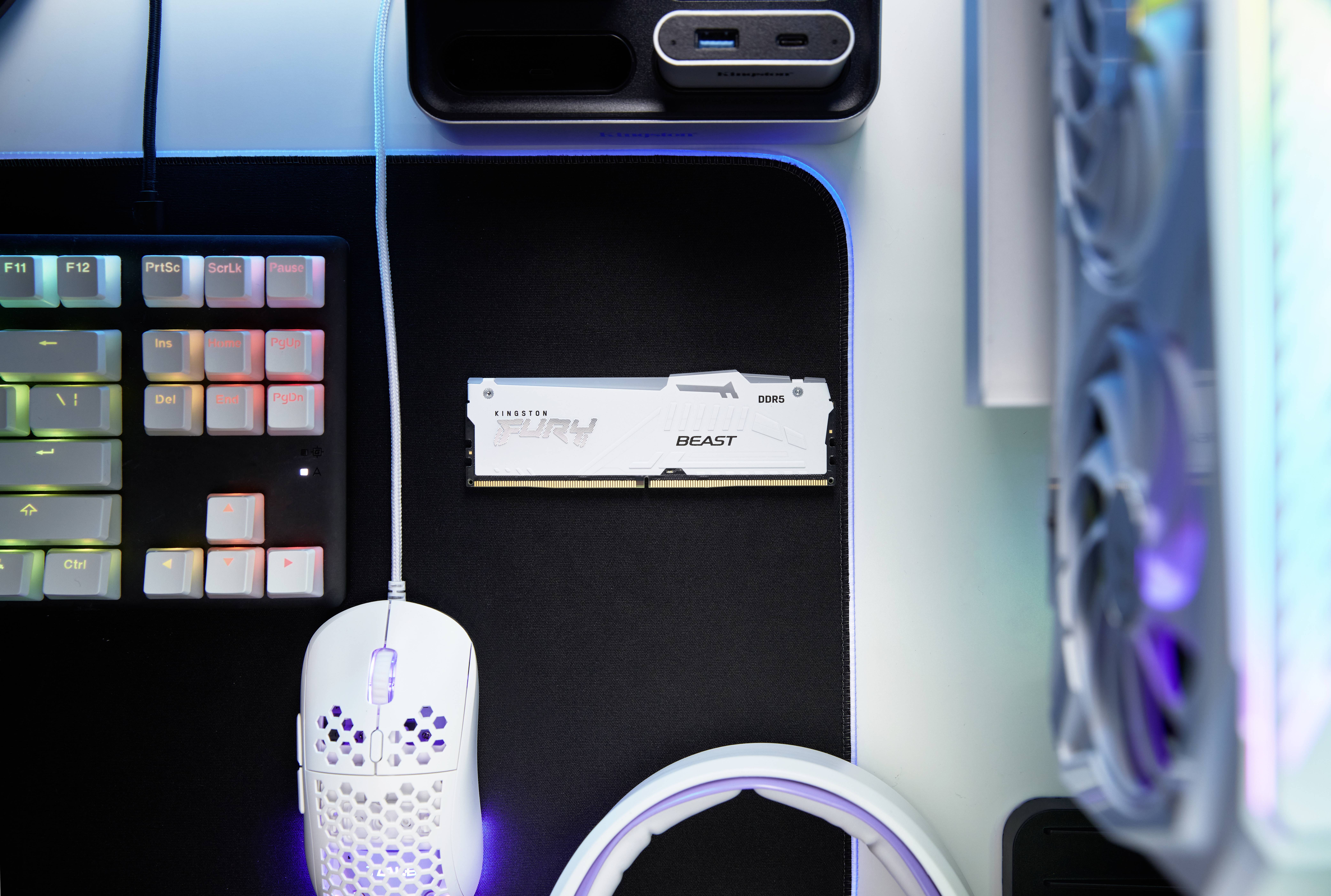 Computermaus und Tastatur auf einem Schreibtisch neben Computerkomponenten.
