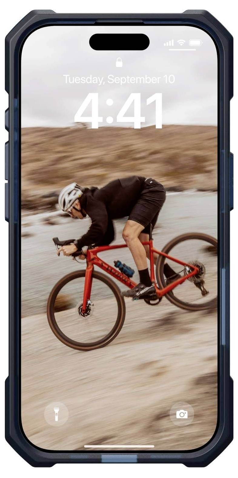 Ein Radfahrer in schwarzer Sportkleidung fährt auf einem roten Fahrrad einen Hügel hinab. Auf dem Smartphone-Bildschirm ist die Uhrzeit 4:41 zu sehen.