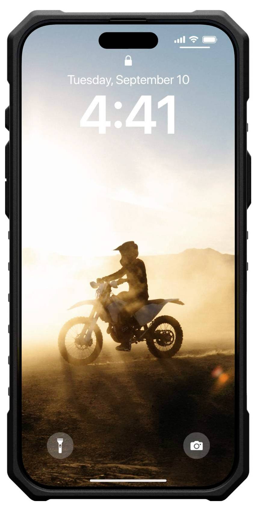 Motorradfahrer fährt im Sand bei Sonnenuntergang.