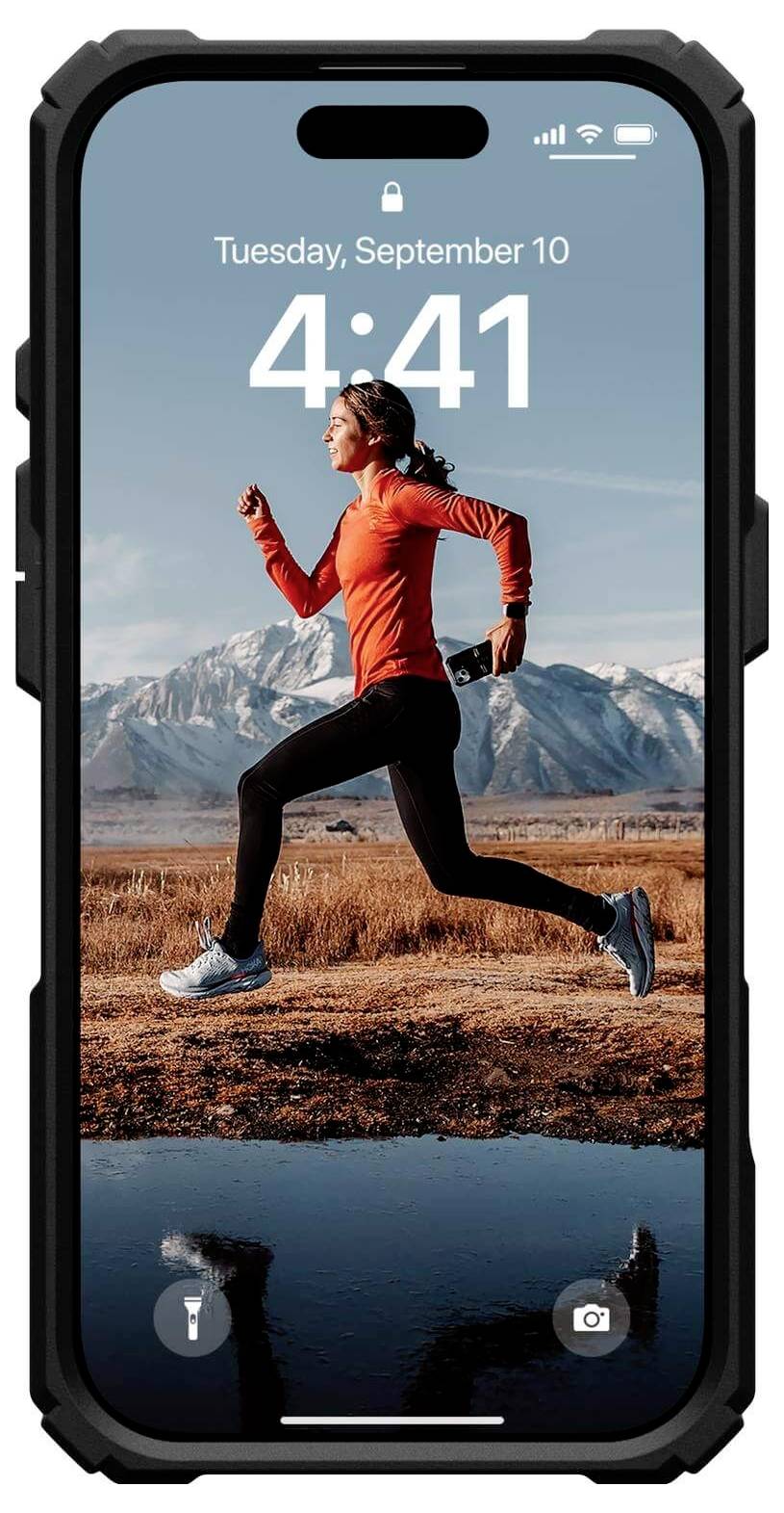 Eine Person in Sportkleidung joggt in einer Landschaft mit Bergen im Hintergrund. Das Smartphone-Display zeigt Datum und Uhrzeit.