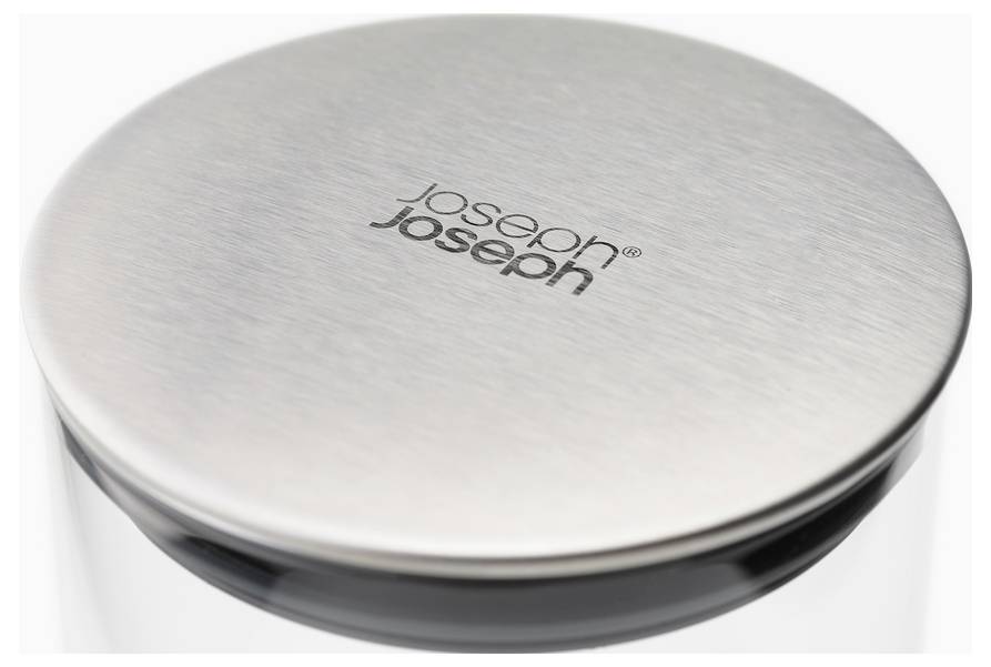 Ein runder Deckel aus gebürstetem Metall mit dem Logo 'joseph joseph' in der Mitte. Der Deckel gehört vermutlich zu einem Haushaltsgerät oder Behälter.