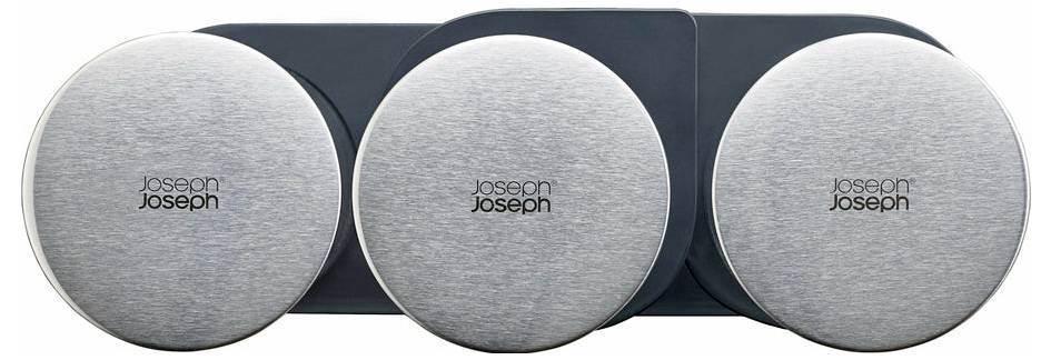 Drei runde, silberne Deckel auf einer dunklen Unterlage. Auf jedem Deckel steht 'Joseph Joseph'. Sie sind gleichmäßig angeordnet.