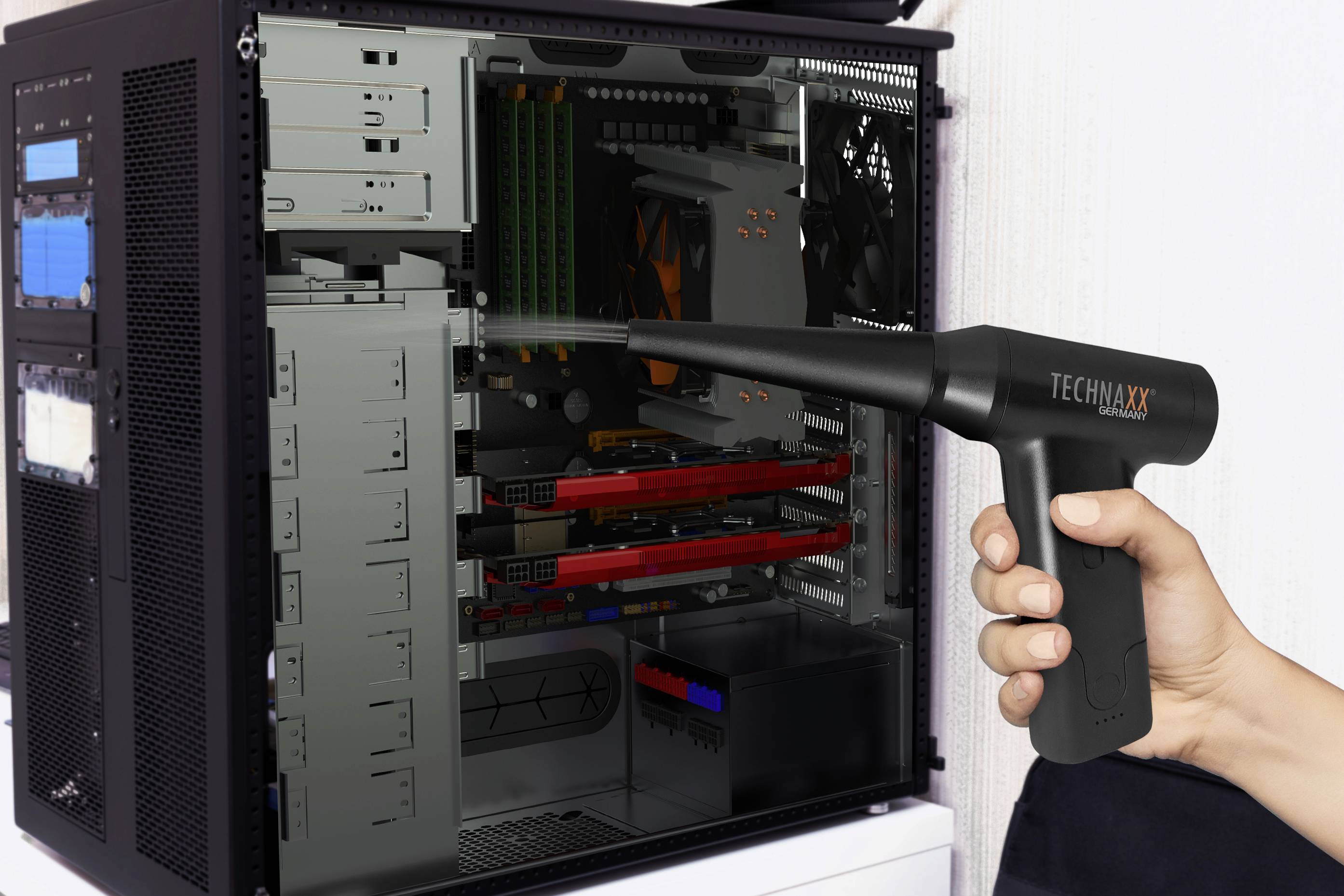 Eine Person reinigt das Innere eines offenen Computergehäuses mit einem elektrischen Gebläse, um Staub zu entfernen.