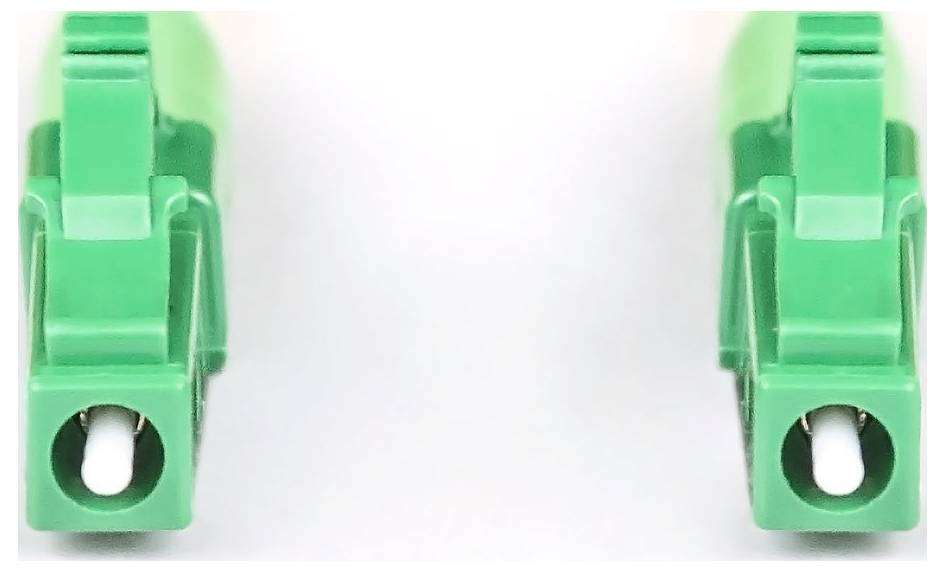 Zwei grüne Kunststoffklemmen für Kabel auf weißem Hintergrund.