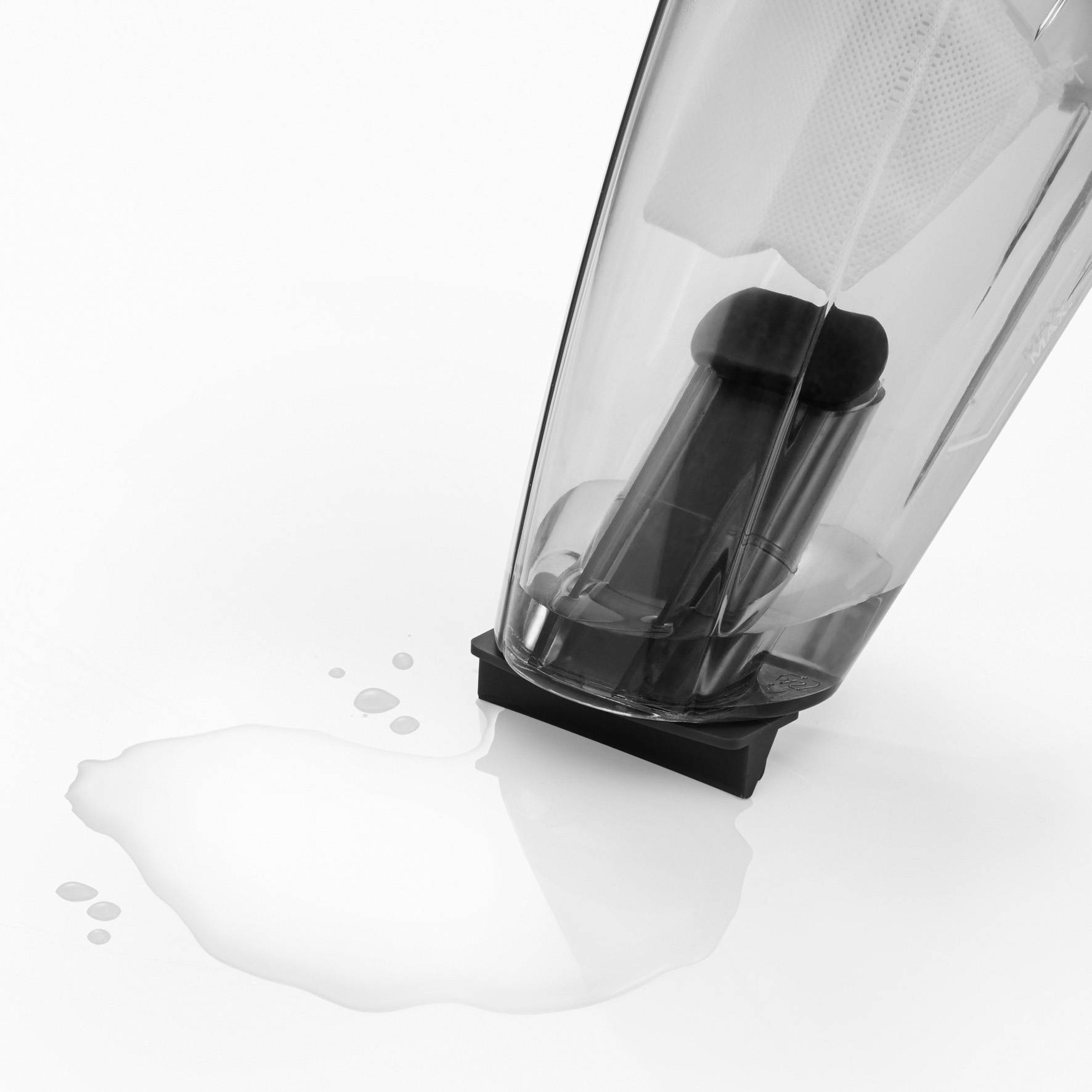 Ein schräg stehender Wasserkocher mit Wasser, das ausläuft, auf einer weißen Oberfläche.