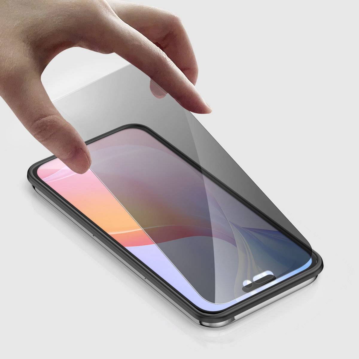 Eine Hand legt eine Schutzfolie auf ein Smartphone-Display.