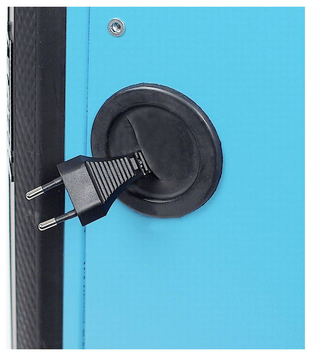 Ein schwarzer Eurostecker ist magnetisch an einer blauen Wand befestigt.