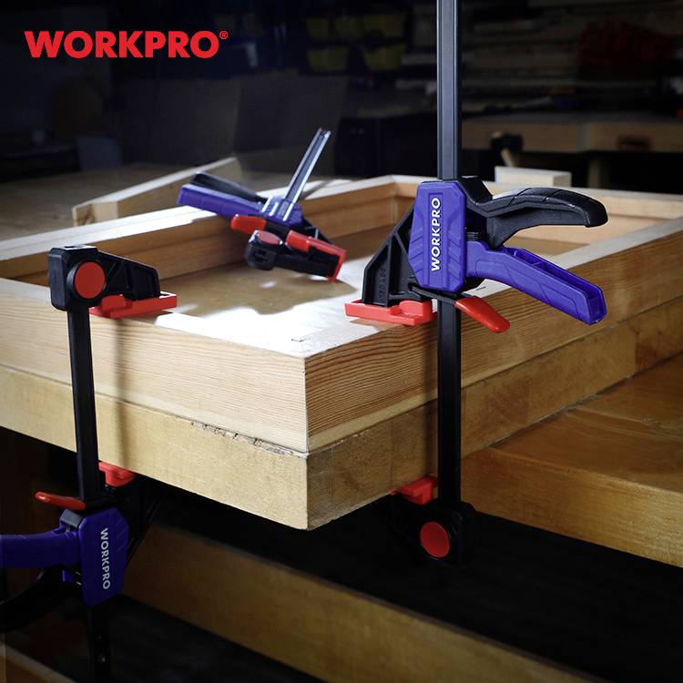 Holzwerkbank mit mehreren Klemmen zur stabilen Befestigung; Marke 'Workpro' sichtbar auf Klemmen.