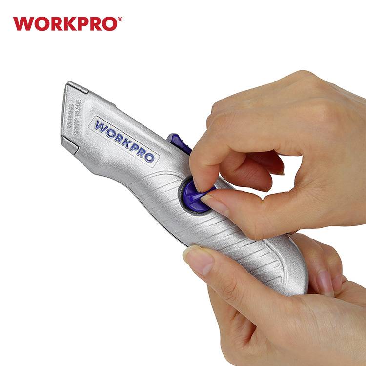 Eine Hand hält ein silberfarbenes Universalmesser von WORKPRO, Daumen auf dem blauen Schalter zur Klingenverstellung.