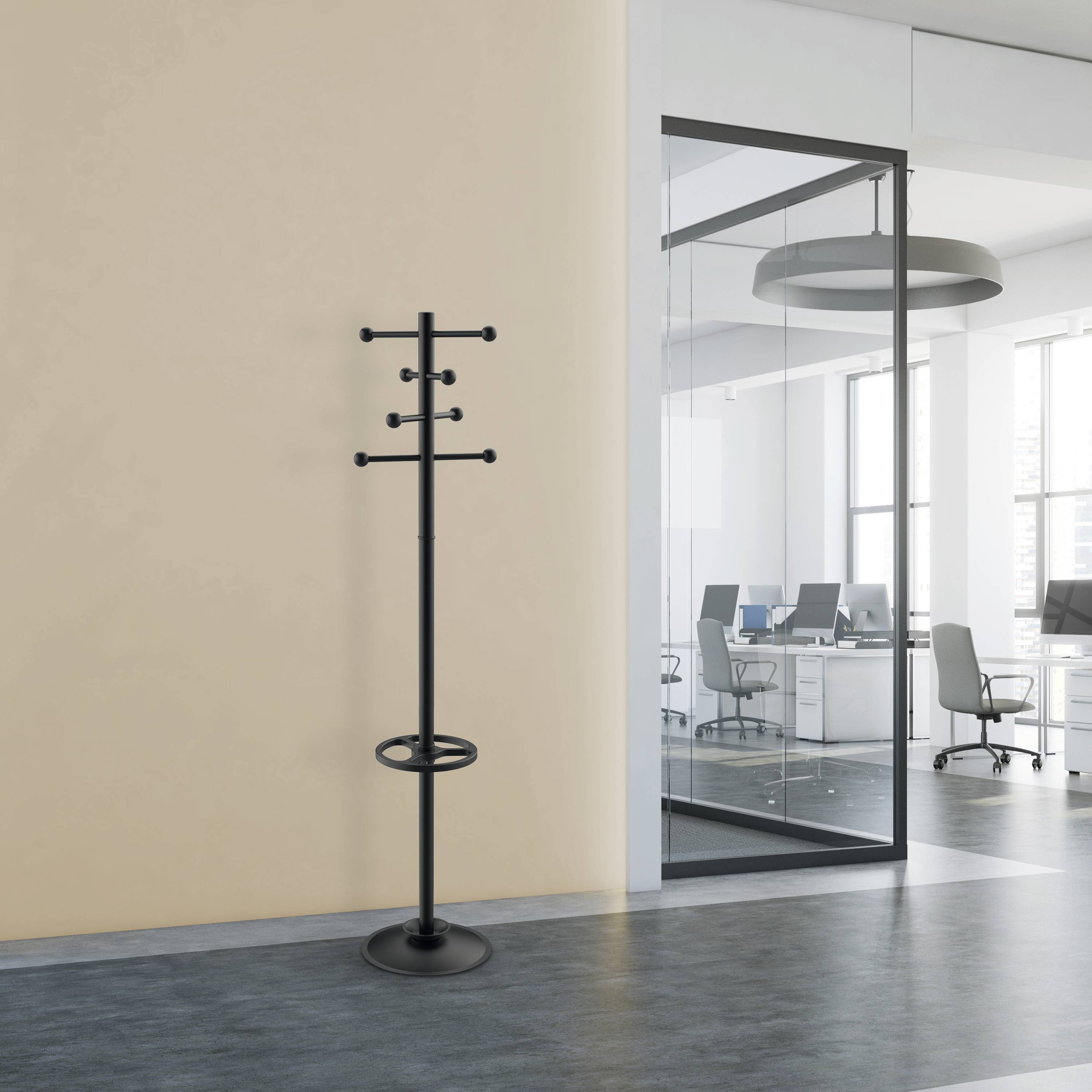 Schwarzer Kleiderständer steht in einem modernen Büroflur. Im Hintergrund ein Glasbüro mit Schreibtischen und Stühlen.