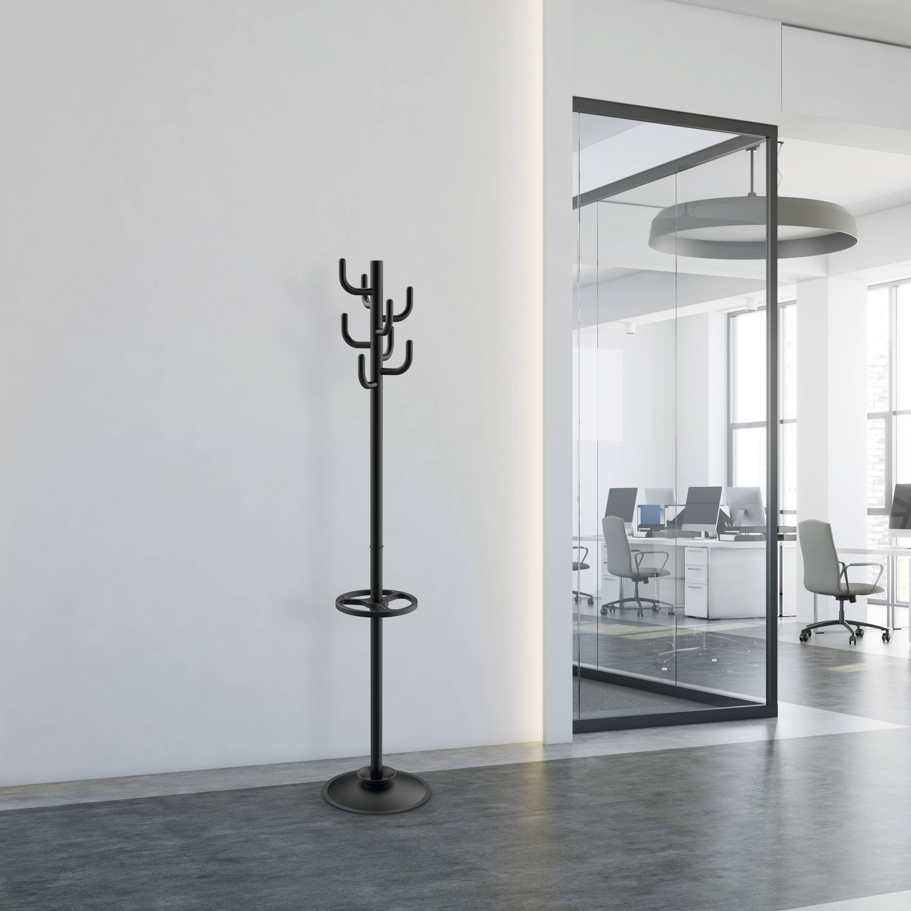 Schwarzer Kleiderständer in modernem Büroflur mit Glaswand. Büro mit Schreibtischen und Stühlen im Hintergrund.