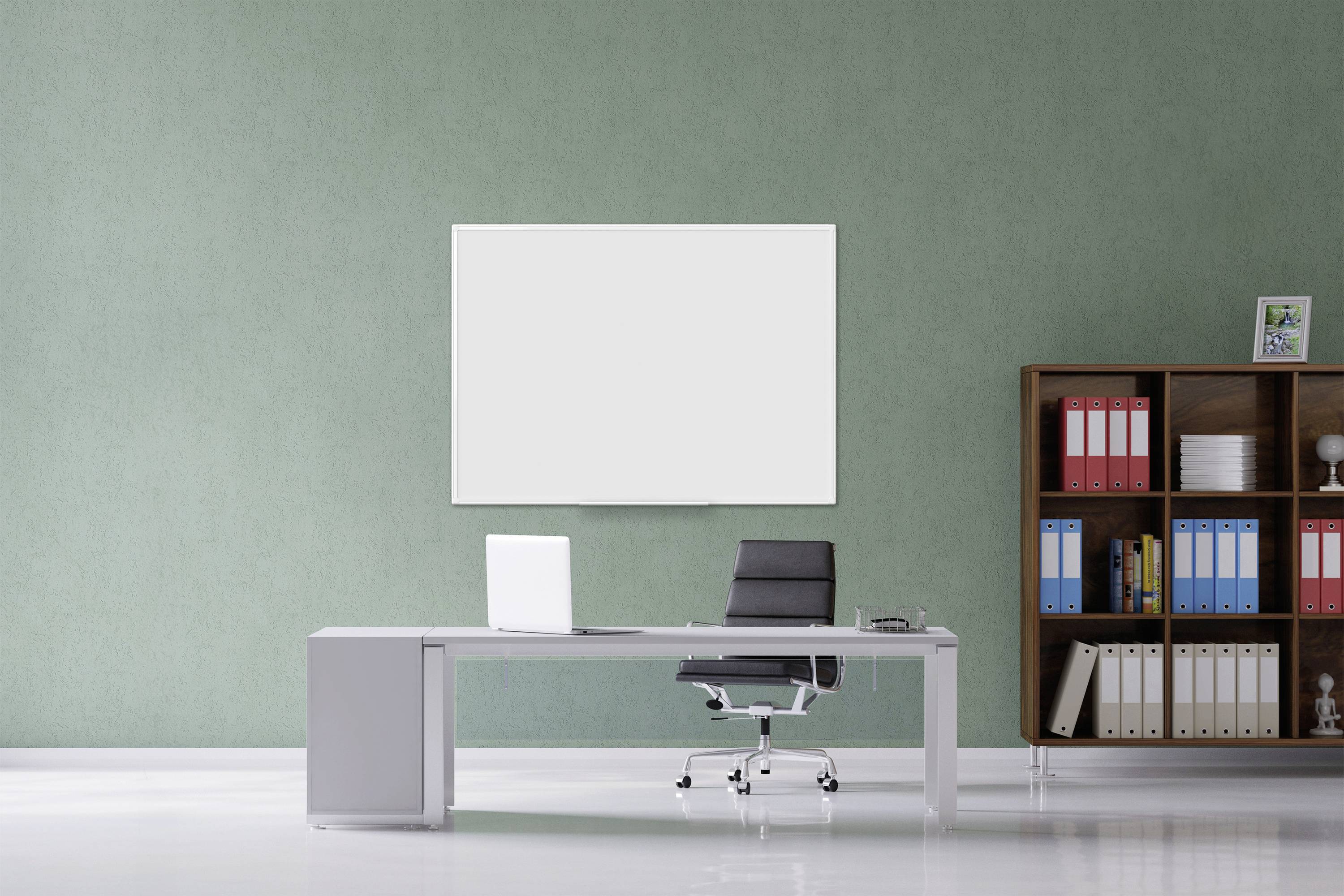Ein modernes Büro mit grauem Schreibtisch, schwarzem Bürostuhl, Laptop und Bücherregal. Leere Tafel an der grünen Wand.