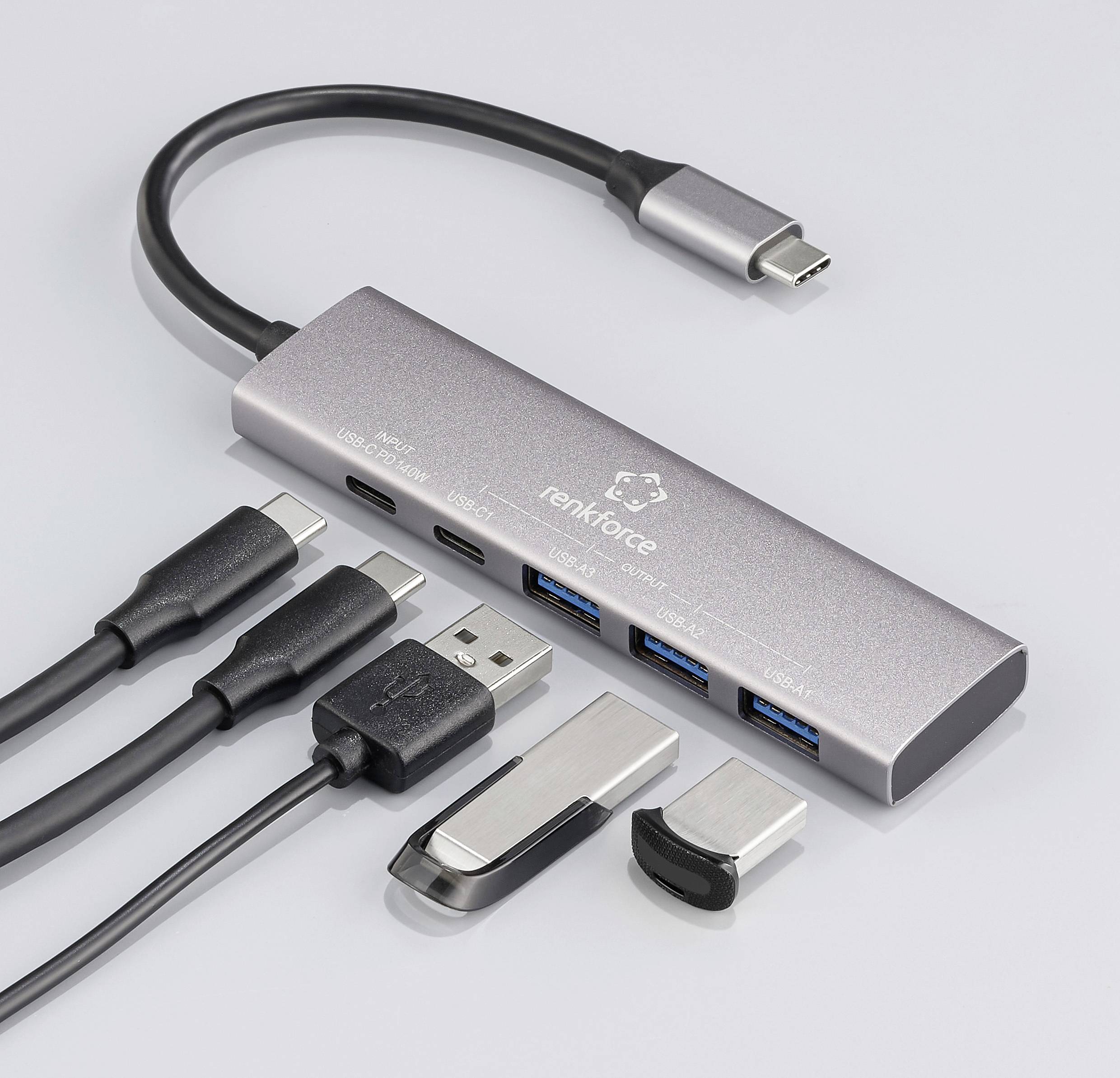 Ein USB-C-Hub mit mehreren Anschlüssen: zwei USB-A, zwei USB-C und HDMI. Angeschlossene Kabel liegen daneben. Ideal für Laptops.