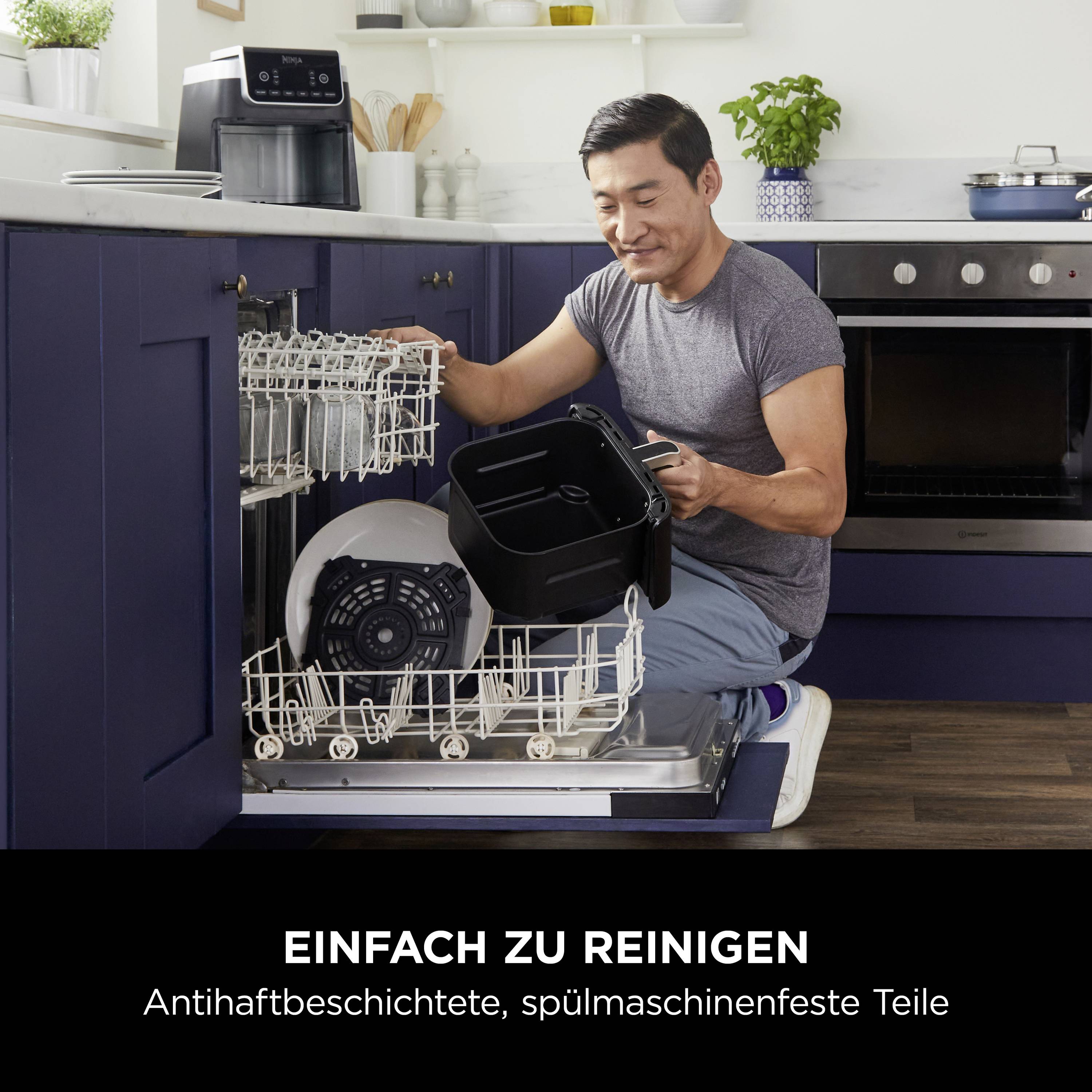 Mann belädt Geschirrspüler mit schwarzen Küchenutensilien. Text unten lautet: 'Einfach zu reinigen. Antihaftbeschichtete, spülmaschinenfeste Teile'.