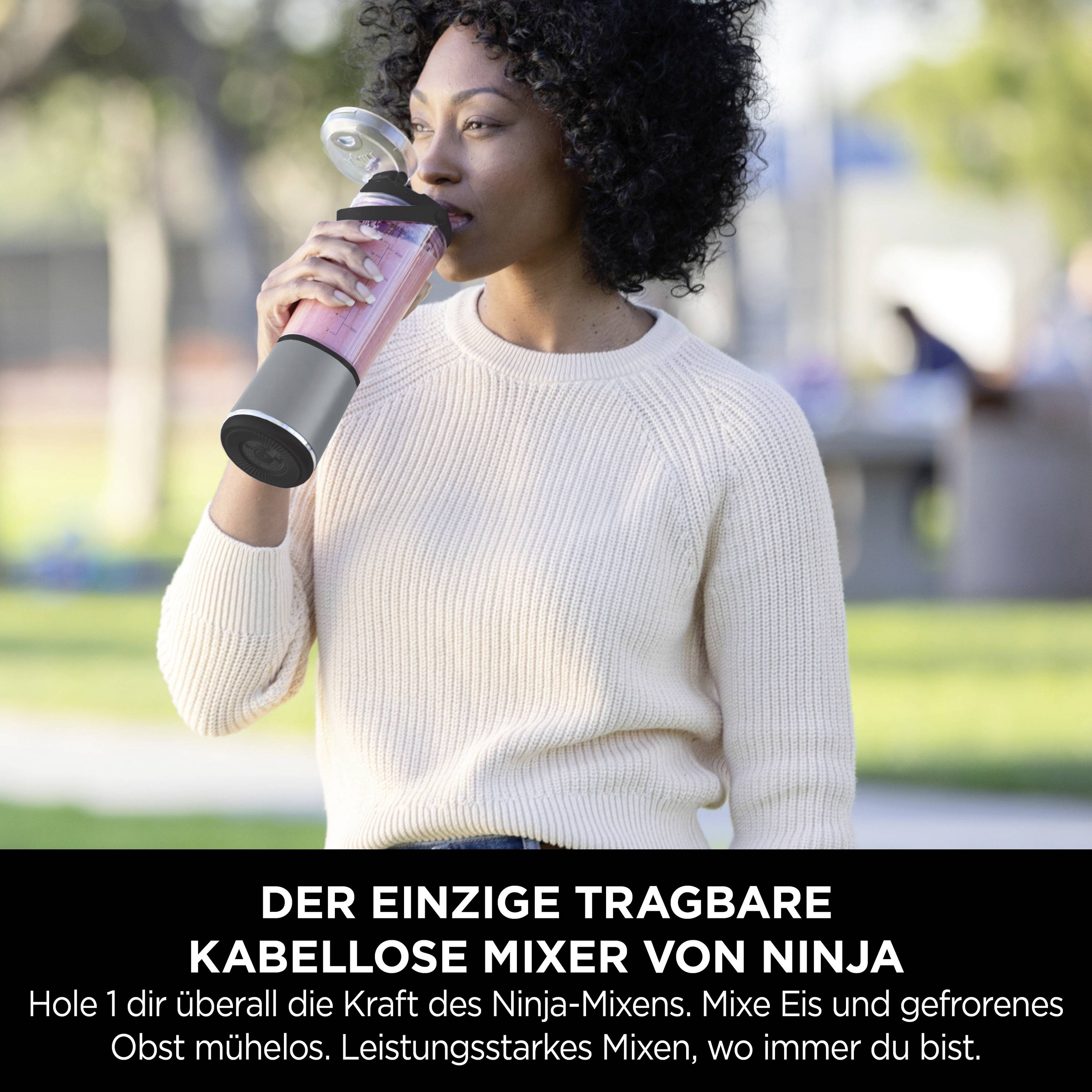 Frau trinkt aus einem tragbaren Mixer in einem Park. Text: 'Der einzige tragbare kabellose Mixer von Ninja'.