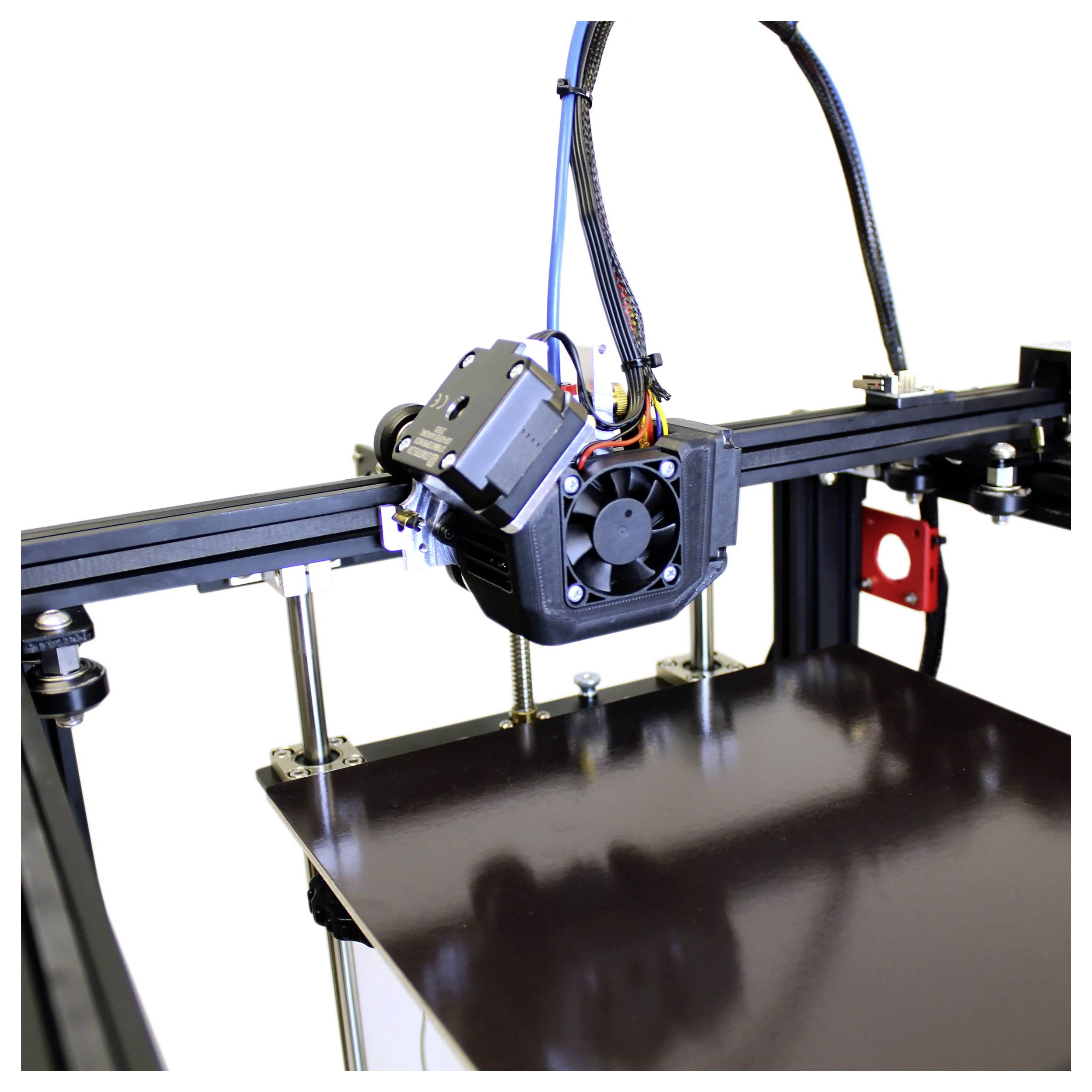 Ein 3D-Drucker mit einem Druckkopf, der sich über einer glänzenden Bauplattform auf einem schwarzen Metallrahmen befindet.