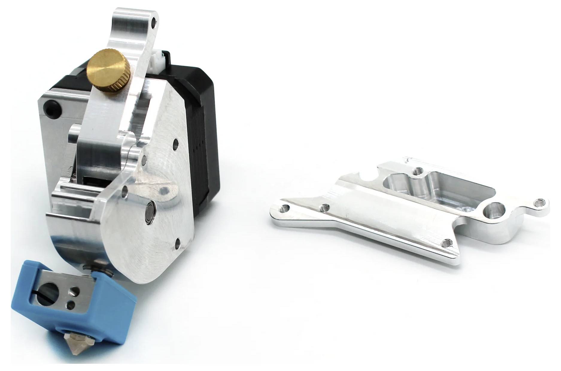 Nahaufnahme von metallischen mechanischen Teilen, einschließlich einer schwarzsilbernen Baugruppe mit einem goldenen Knopf und einer separaten silbernen Halterung auf weißem Hintergrund.