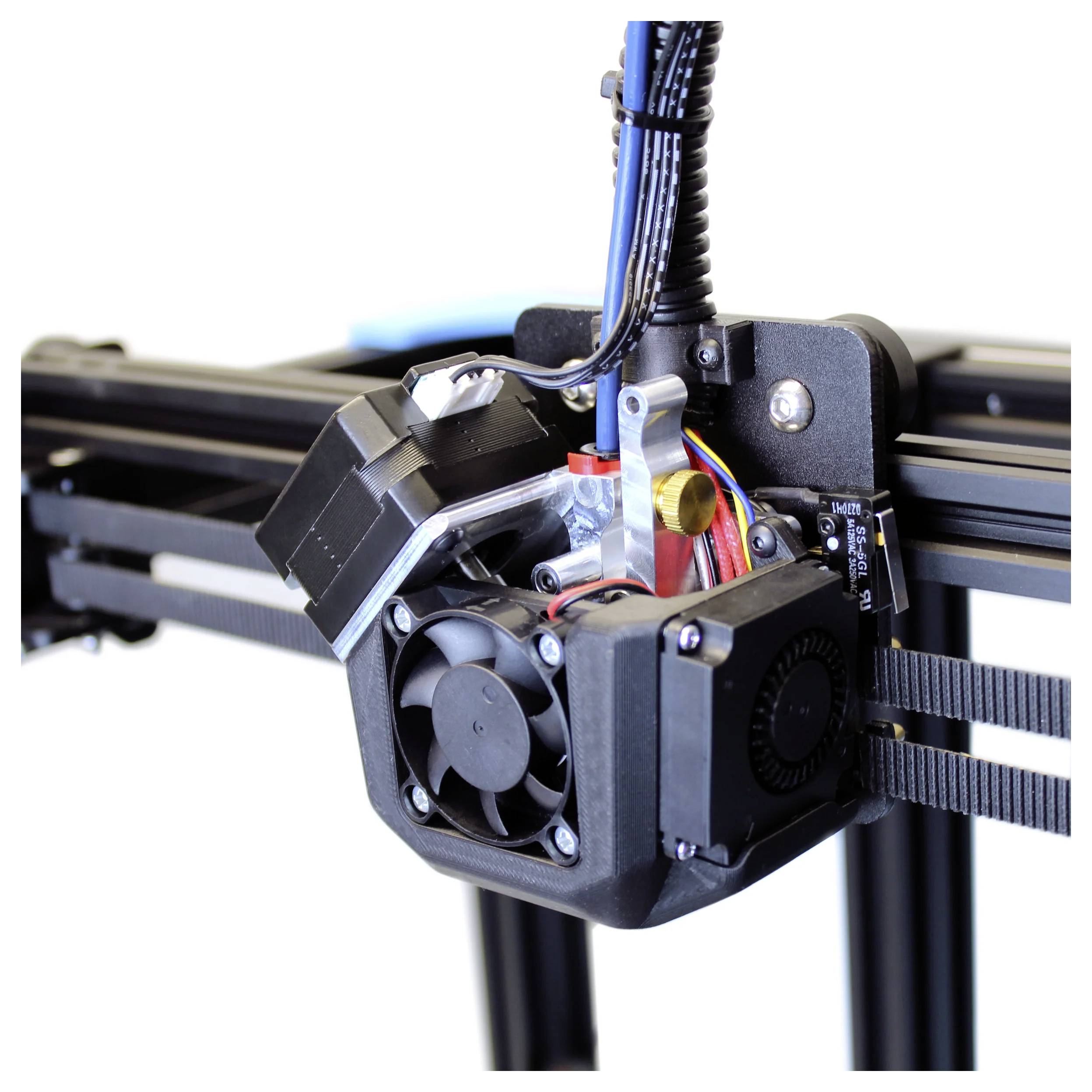 Nahaufnahme eines 3D-Drucker-Extruders und eines Kühlventilators, die auf dem Druckkopf montiert sind, mit sichtbarer Verkabelung und Schienen.