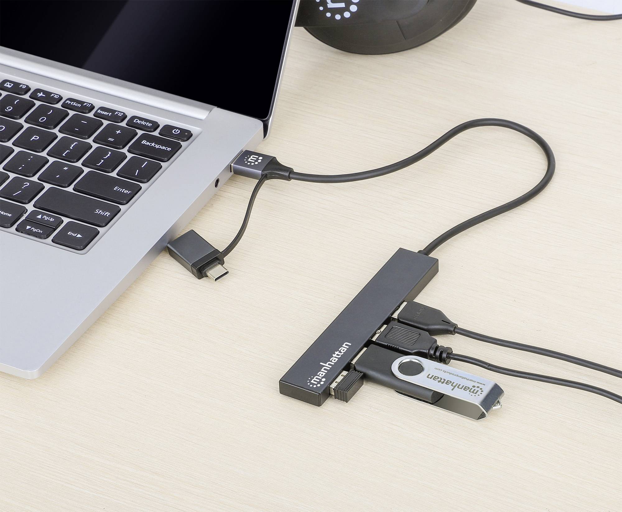 Ein Laptop ist über ein USB-Hub mit mehreren Geräten verbunden, darunter ein USB-Stick und ein Kartenleser.
