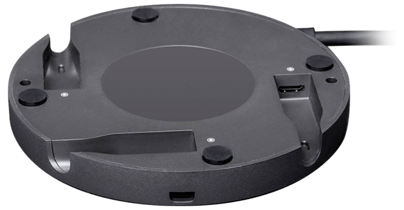 Rundes, schwarz-graues Gerät mit mehreren Anschlüssen, einschließlich USB und HDMI, auf einer glatten Oberfläche platziert.