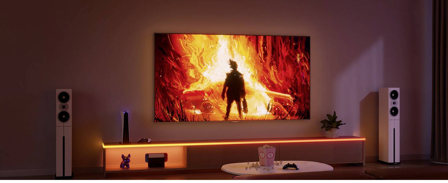 Ein Wohnzimmer mit Heimkino-Setup: Ein großer Fernseher zeigt eine brennende Filmszene, umgeben von Lautsprechern, Pflanzen, und einem langen Regal.