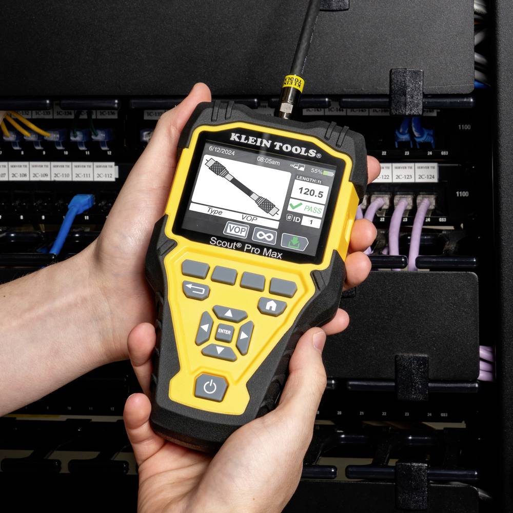 Eine Person hält ein gelbes Scouting-Werkzeug vor einem Netzwerk-Server-Schrank. Das Display zeigt verschiedene Messwerte an.