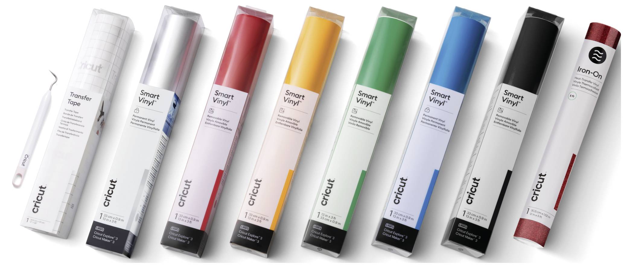 Acht Rollen Cricut Smart Vinyl in verschiedenen Farben stehen nebeneinander, inklusive einer Rolle Transferband und ein Cricut Werkzeug.