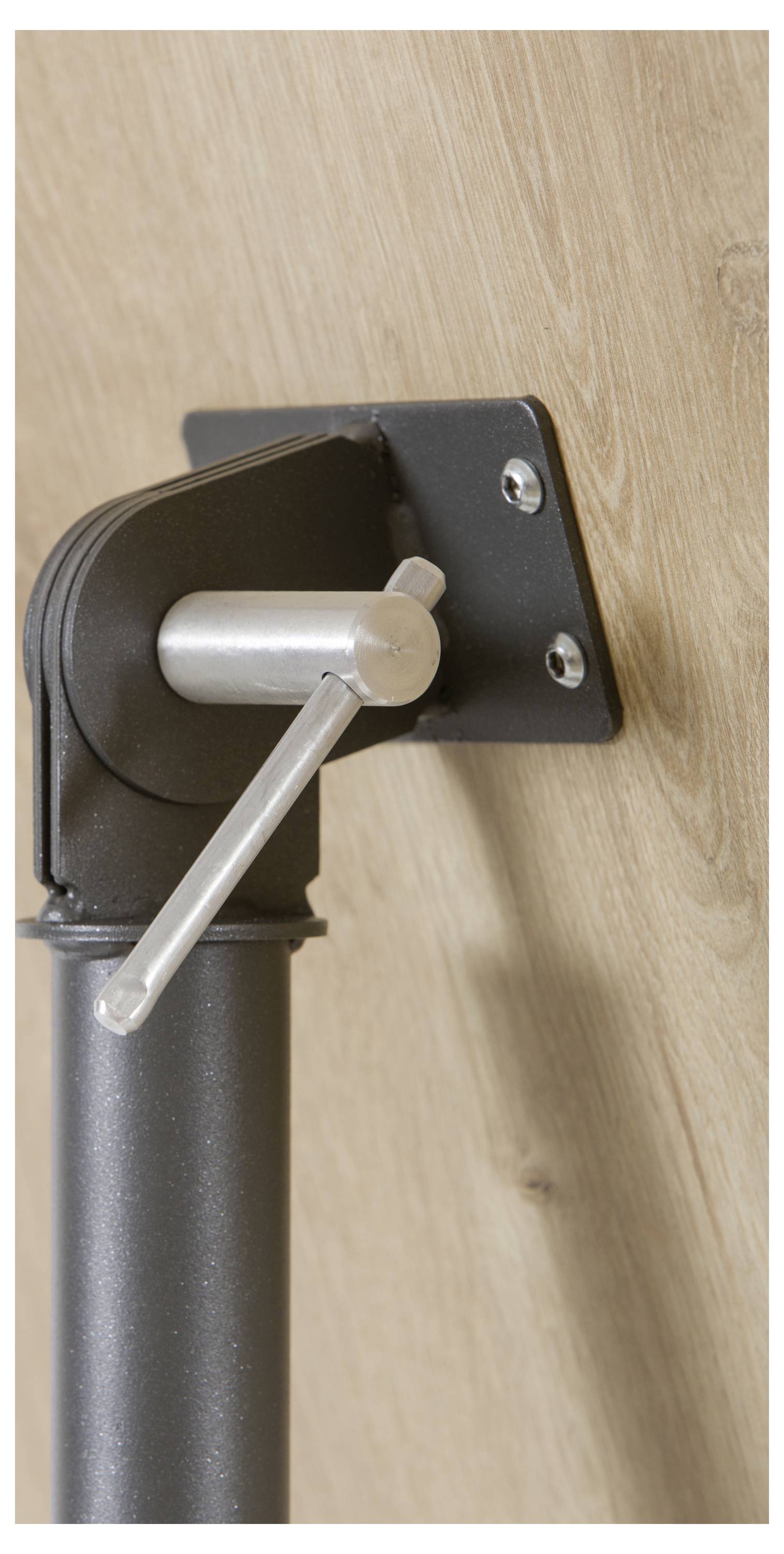 Ein schwarzes Metallscharnier mit silbernem Hebel an einer Holztür befestigt.