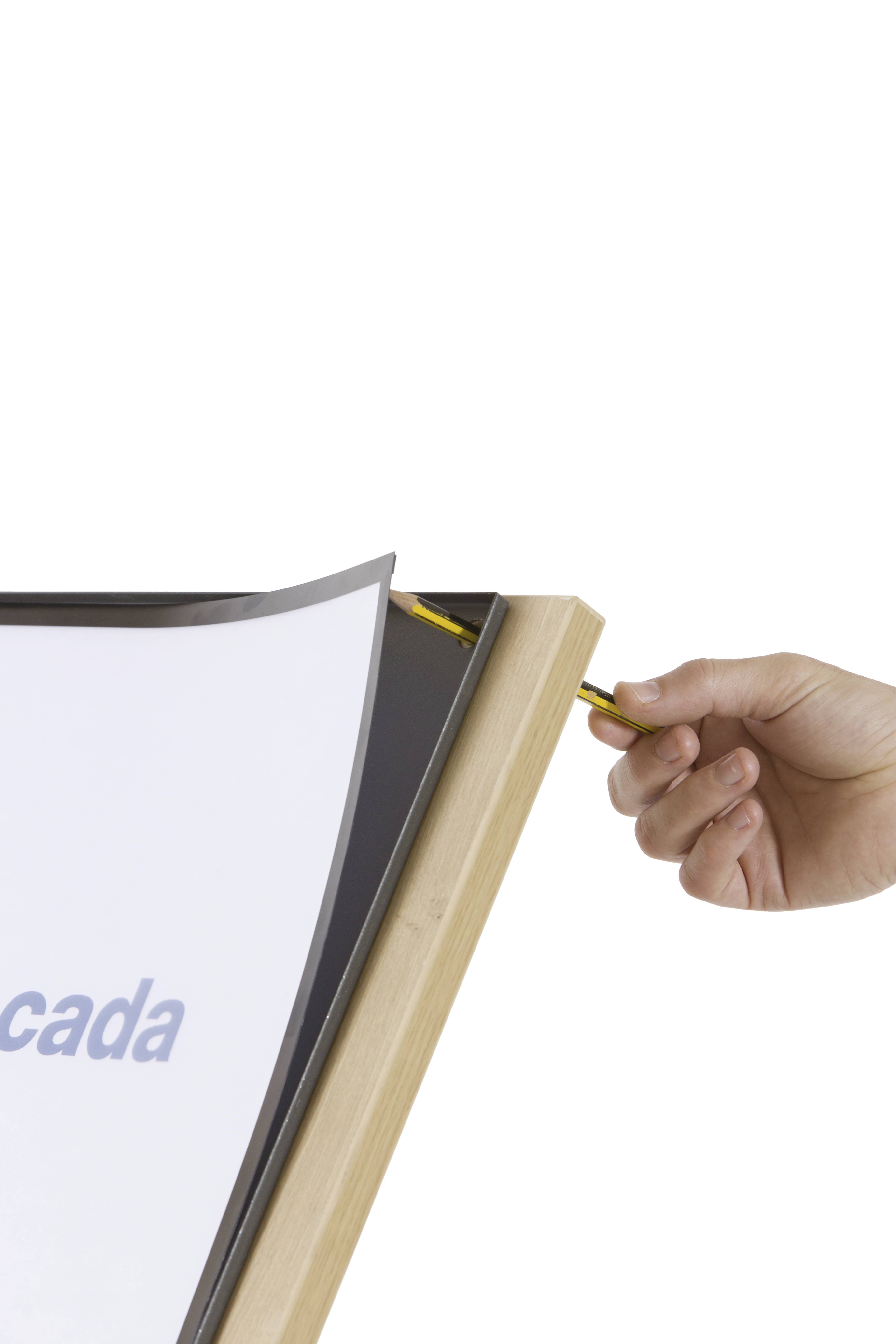 Eine Hand legt einen Bleistift in eine Halterung eines Holzrahmens an einem Whiteboard.