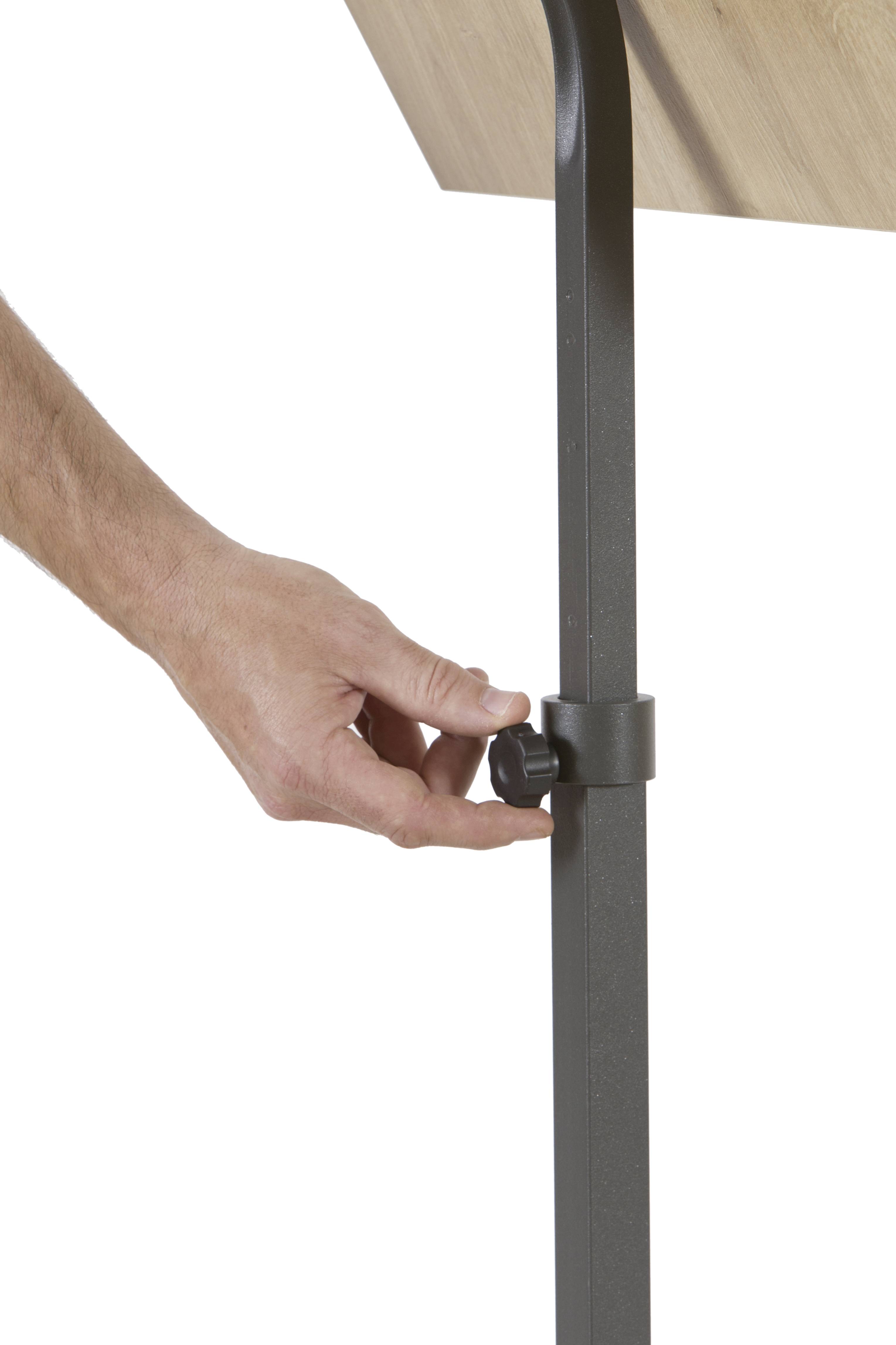 Hand justiert einen schwarzen Hebel an einem Tischbein aus Metall. Der Tisch hat eine Holzplatte.