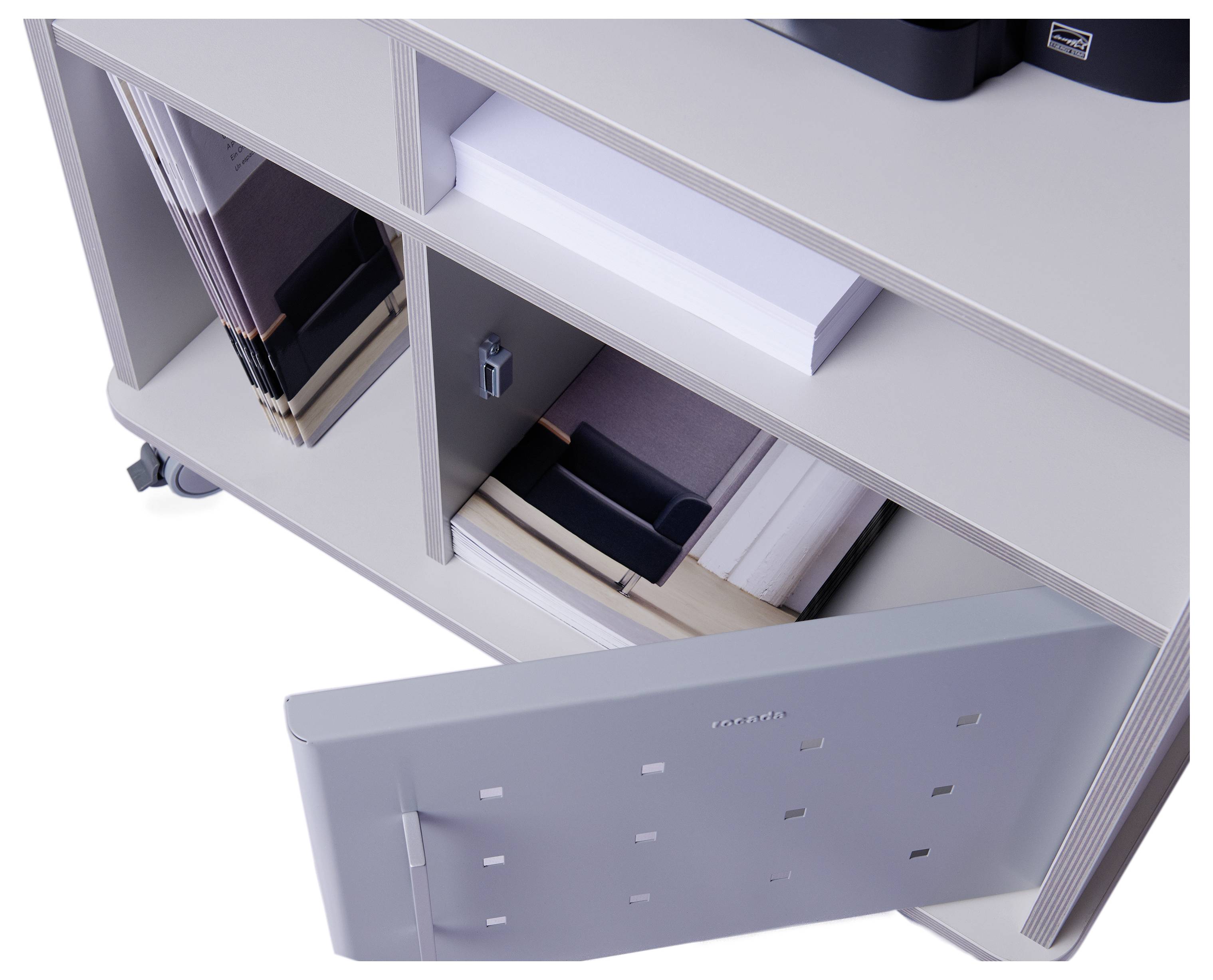 Ein graues Regal auf Rollen mit offenen Regalfächern. Einige Fächer enthalten Ordner, eins ist mit Papieren gefüllt, die Tür eines Fachs ist geöffnet.