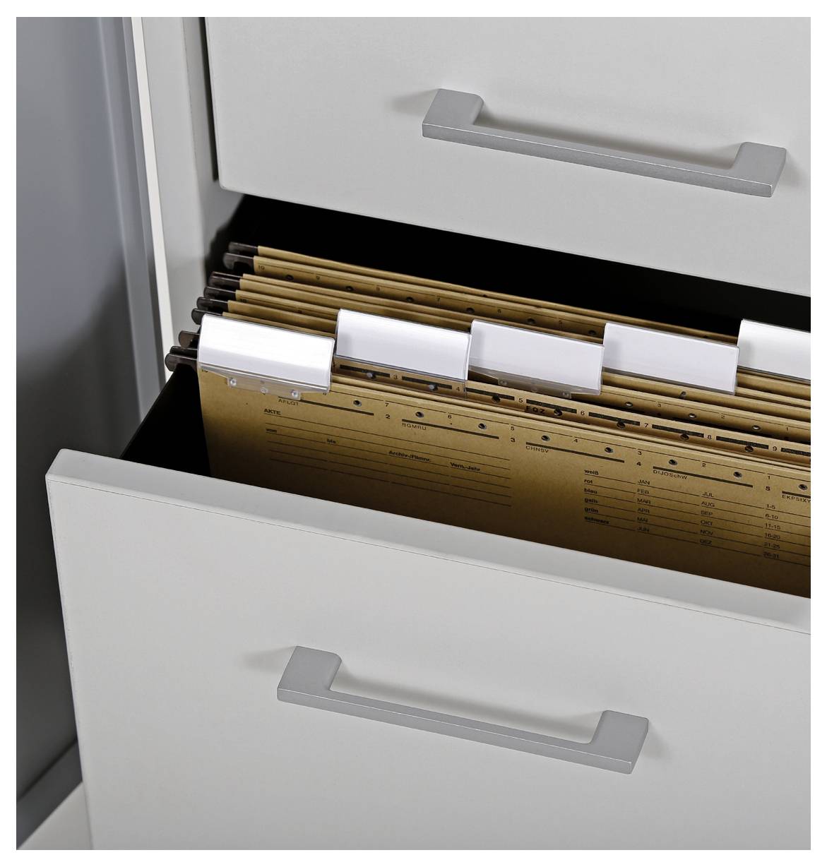 Eine geöffnete Schublade eines Aktenschranks mit mehreren Registermappen.