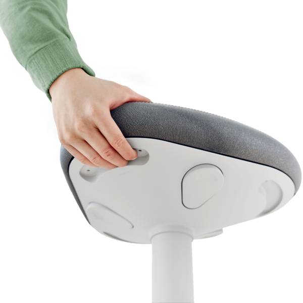 Eine Person hält die Sitzfläche eines modernen, ergonomischen Stuhls mit grauem Bezug, der auf einem weißen Standfuß montiert ist.