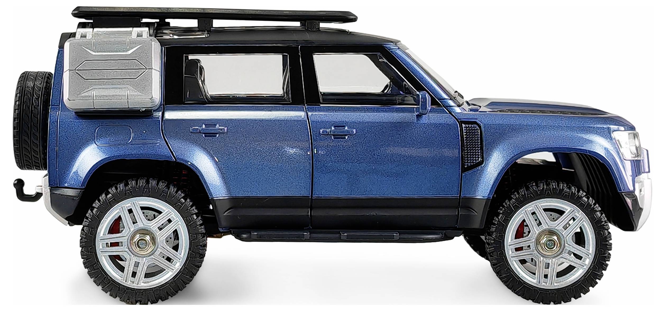 Ein blauer Geländewagen mit großen Reifen und Dachgepäckträger steht seitlich vor einem weißen Hintergrund.