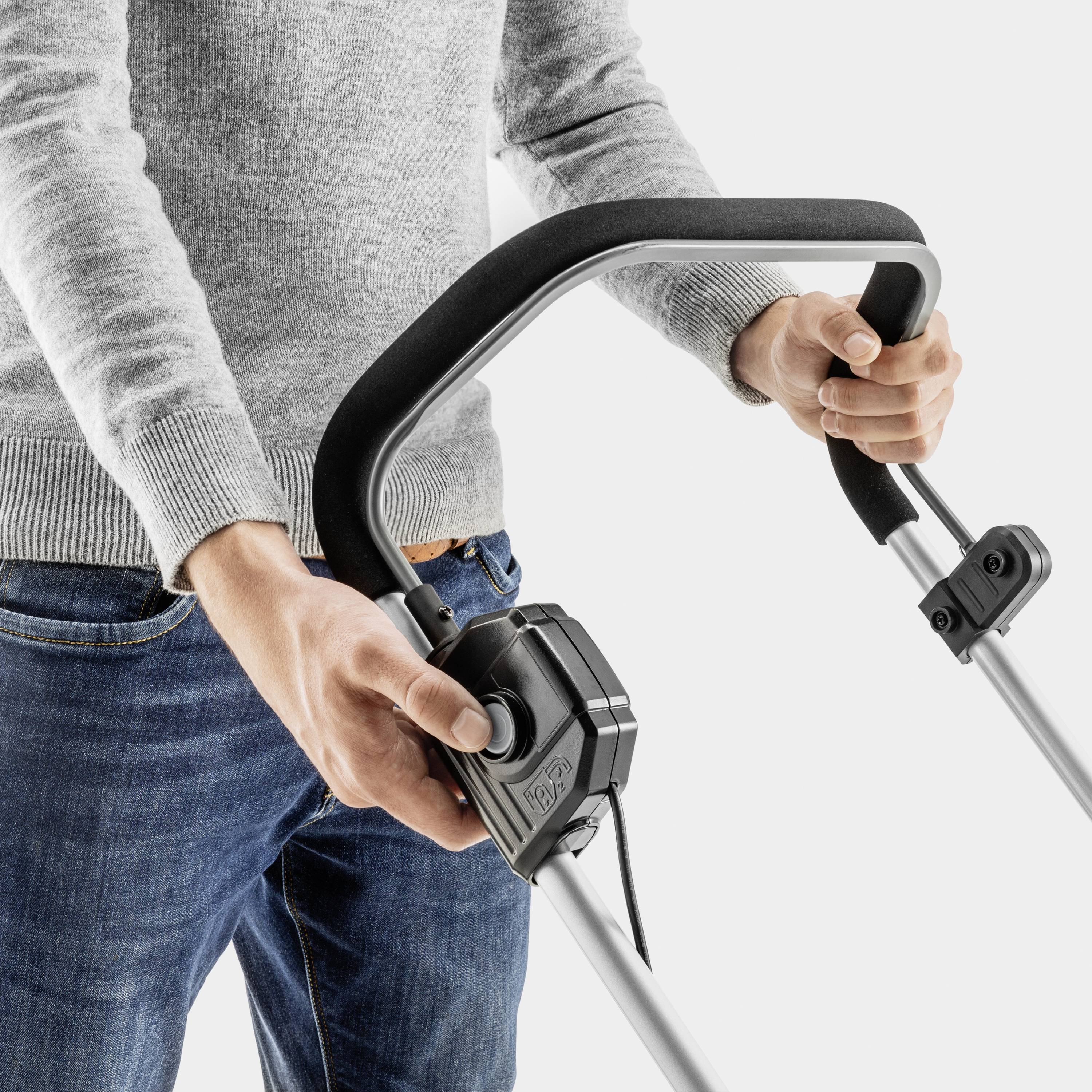 Person schiebt einen modernen Rasenmähergriff mit Leichtigkeit. Fokus auf dem ergonomischen Design des Griffs.