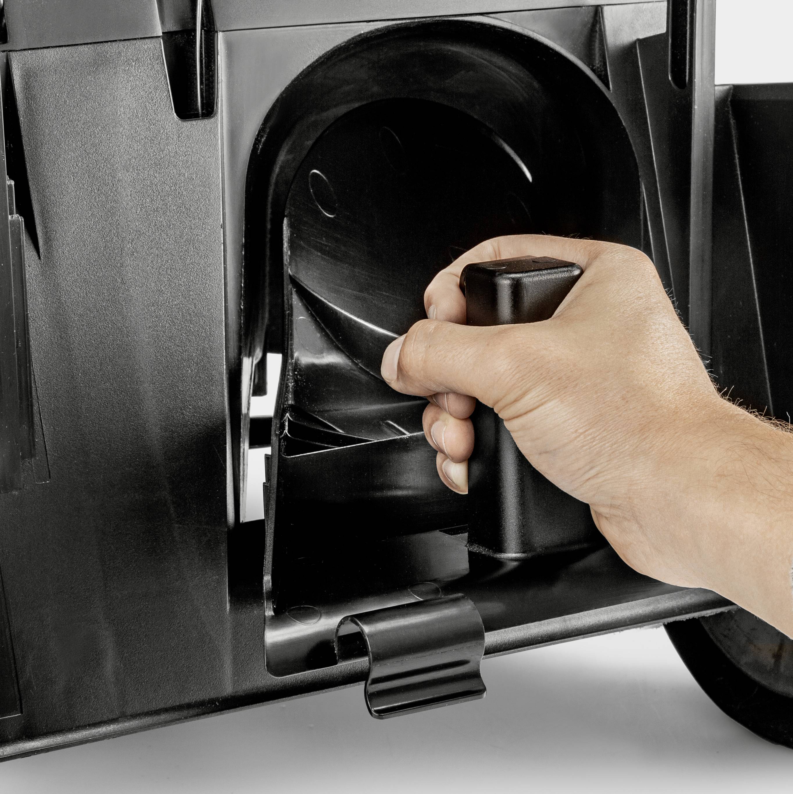 Hand bedient den Hebel einer schwarzen Maschine, wahrscheinlich ein großer Aktenvernichter, um das Gerät zu steuern.