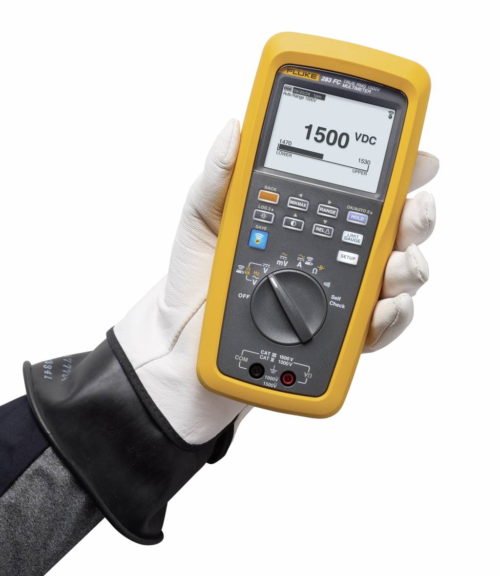 Eine behandschuhte Hand hält ein Multimeter mit digitaler Anzeige. Das Display zeigt '1500 VDC'.