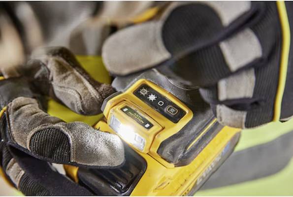 Nahaufnahme von behandschuhten Händen, die ein gelbes Bediengerät mit Tasten und Anzeigedisplay bedienen, was den Fokus auf Funktionalität und Sicherheit verdeutlicht.