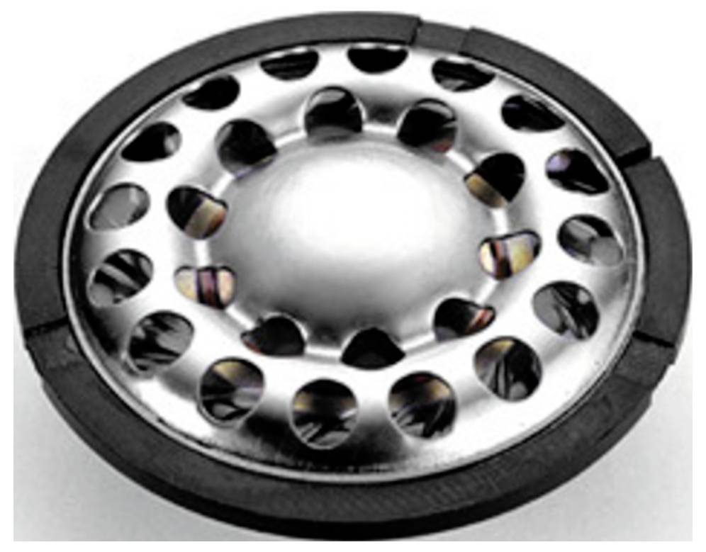 Ein silbernes, rundes Metallobjekt mit gleichmäßig verteilten Löchern am Rand, möglicherweise ein Teil eines mechanischen Geräts.